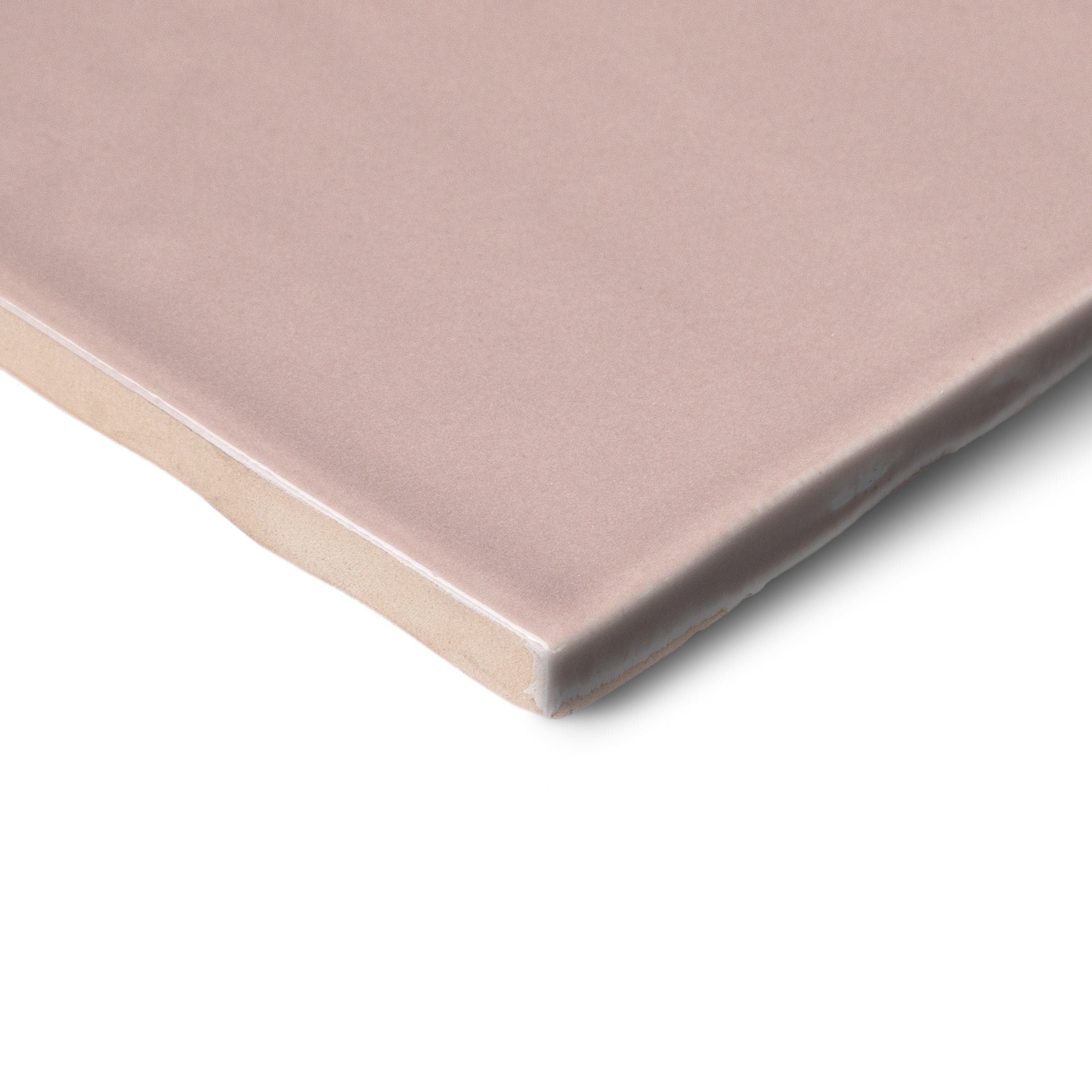 Close-up of a dusty pink ceramic tile corner with a softly rounded edge