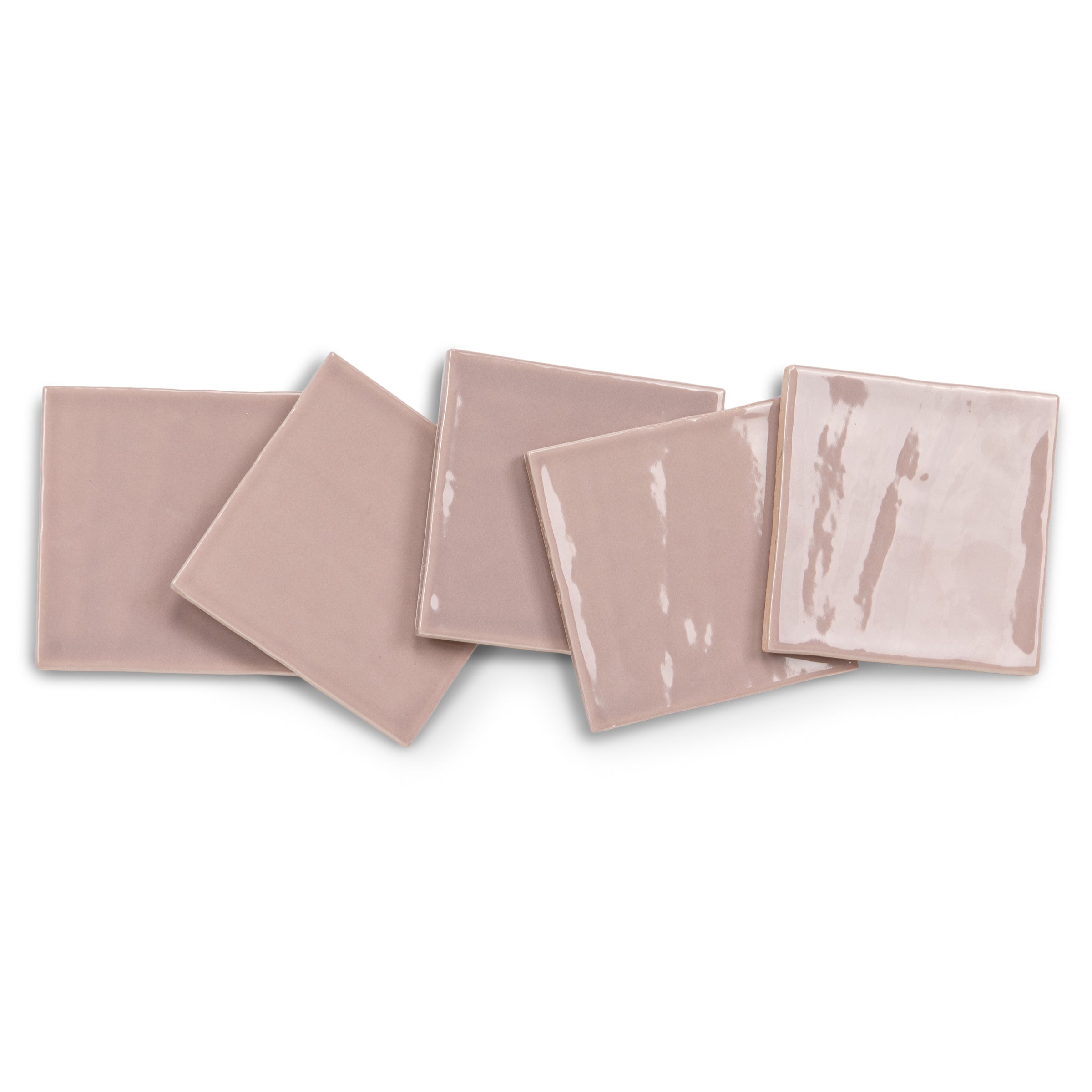 Blush pink glazed ceramic tiles with varied handmade-style surface texture layered on a white background