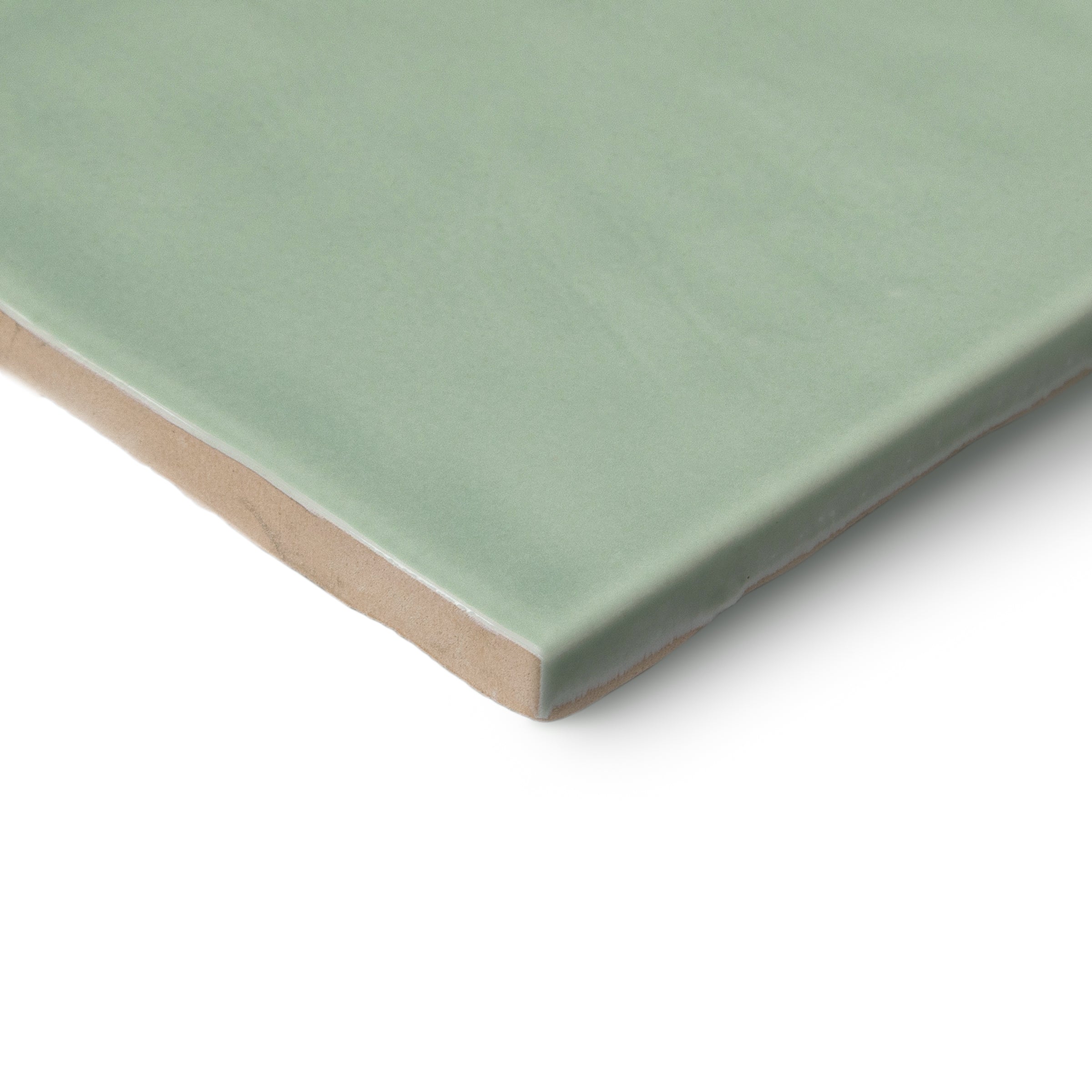 Close view of a pale green glazed ceramic tile with a beige clay edge