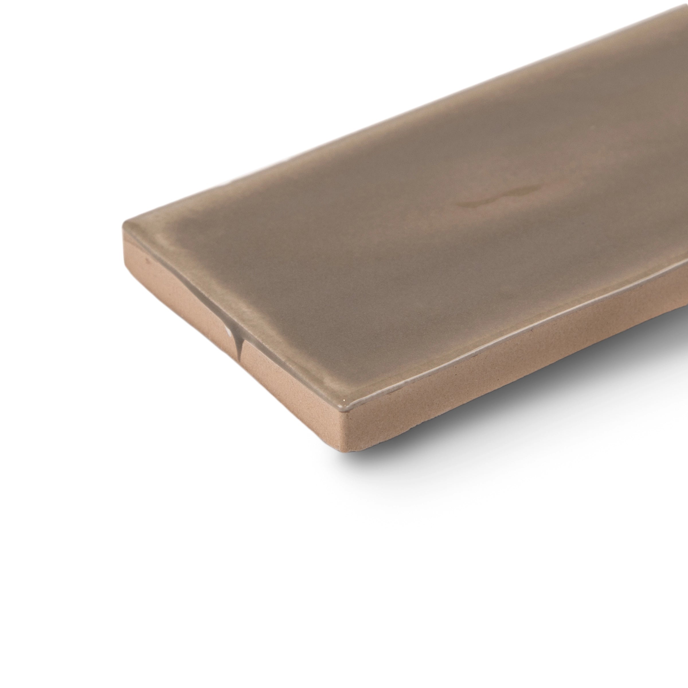 Close-up of a smooth, elongated ceramic tile in muted clay brown with soft edges and a subtle matte finish on white background