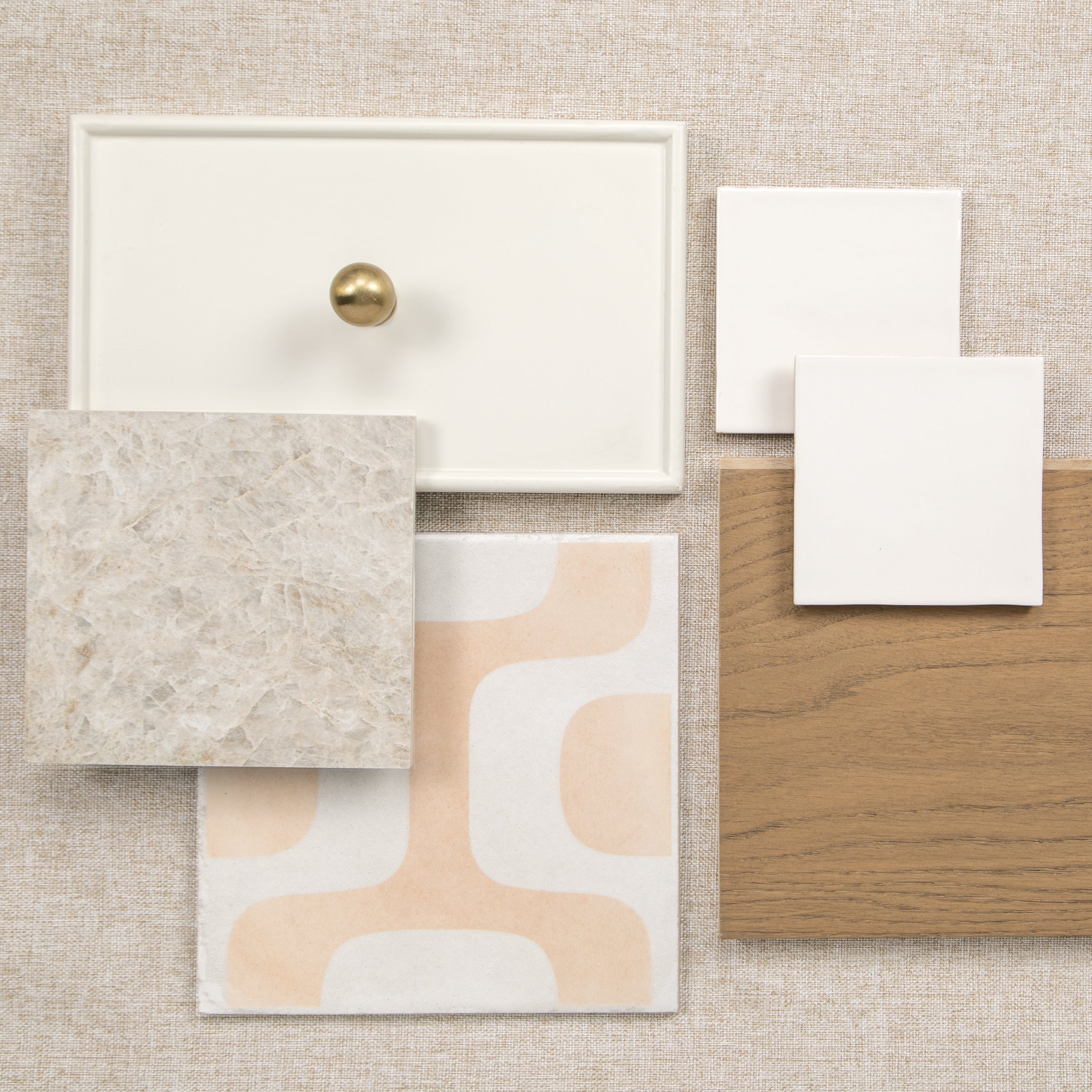 Neutral tile and wood flooring samples arranged on a textured surface