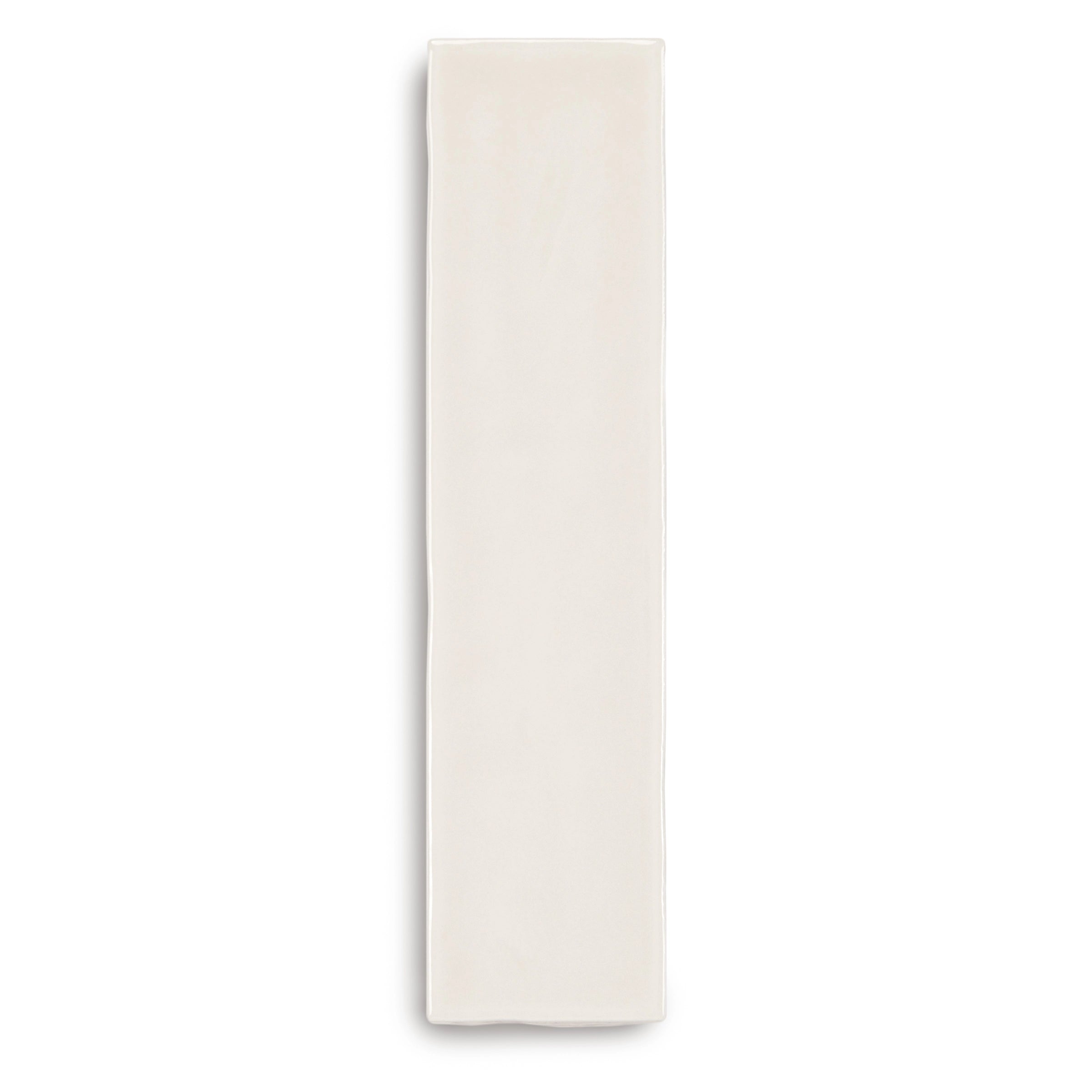 Narrow natural ceramic tile in light cream with a smooth surface and gently irregular edges on white background
