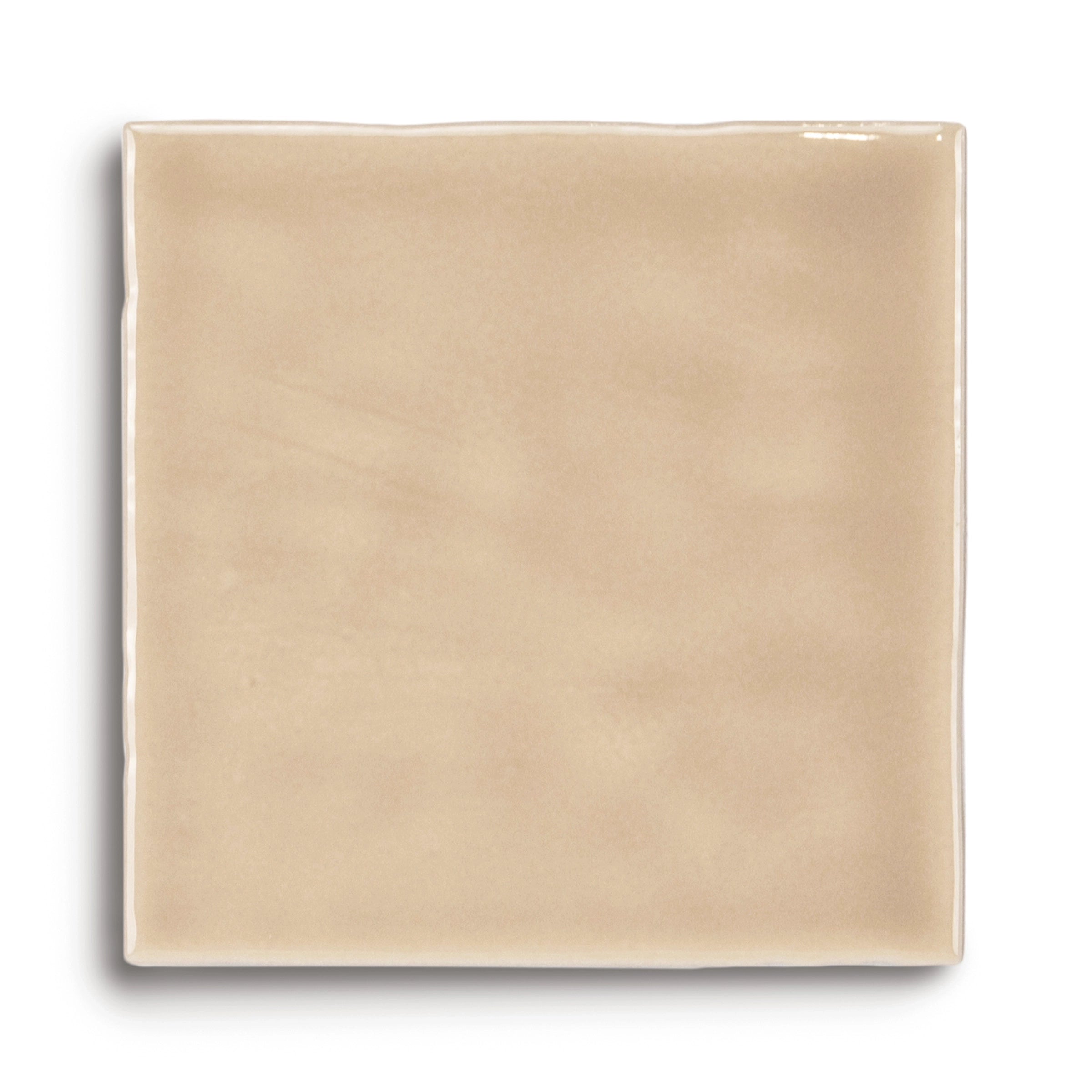 Smooth square ceramic tile in warm beige with a glossy finish and softly rounded edges on white background