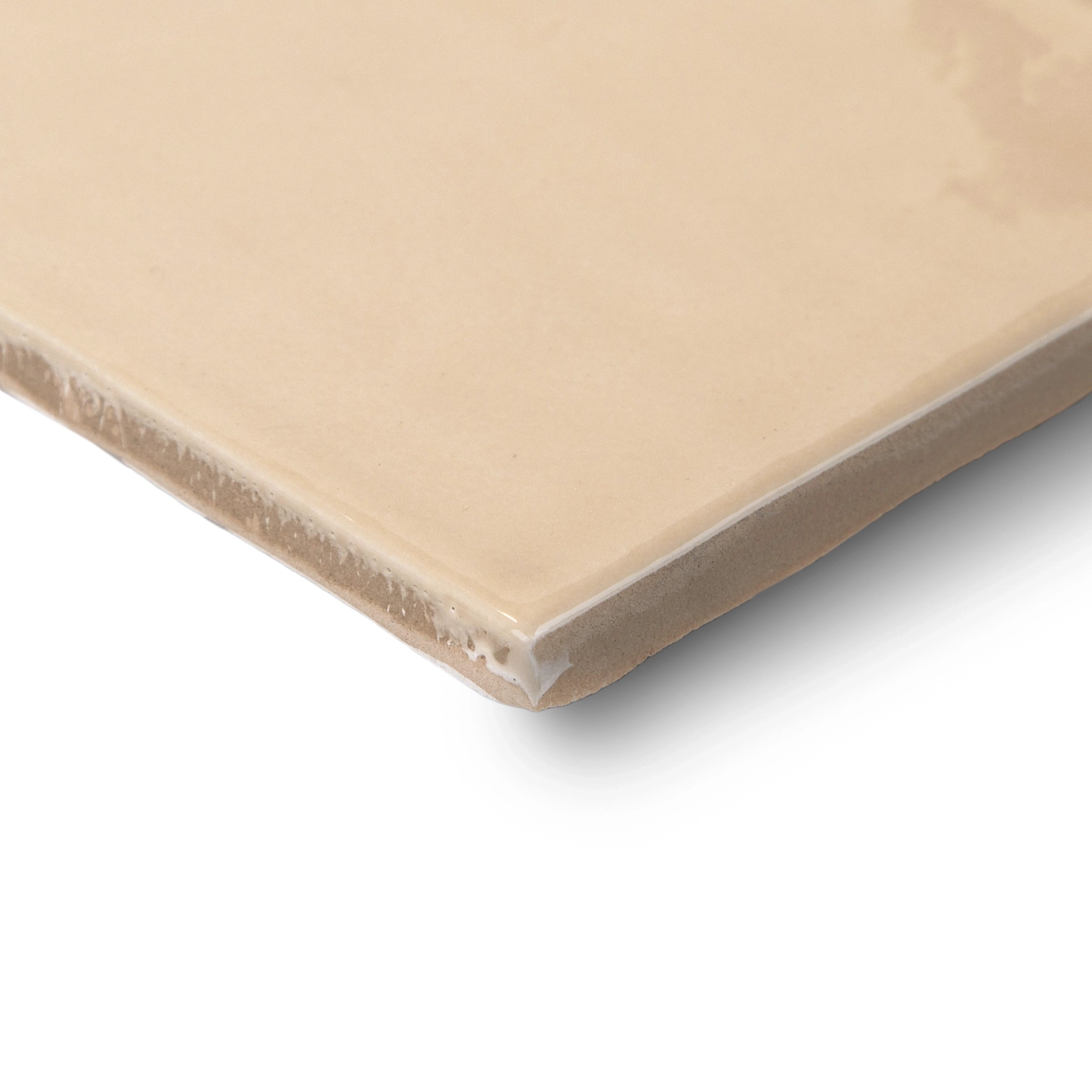 Close-up of a smooth, light beige ceramic tile with slightly beveled edges against a white background
