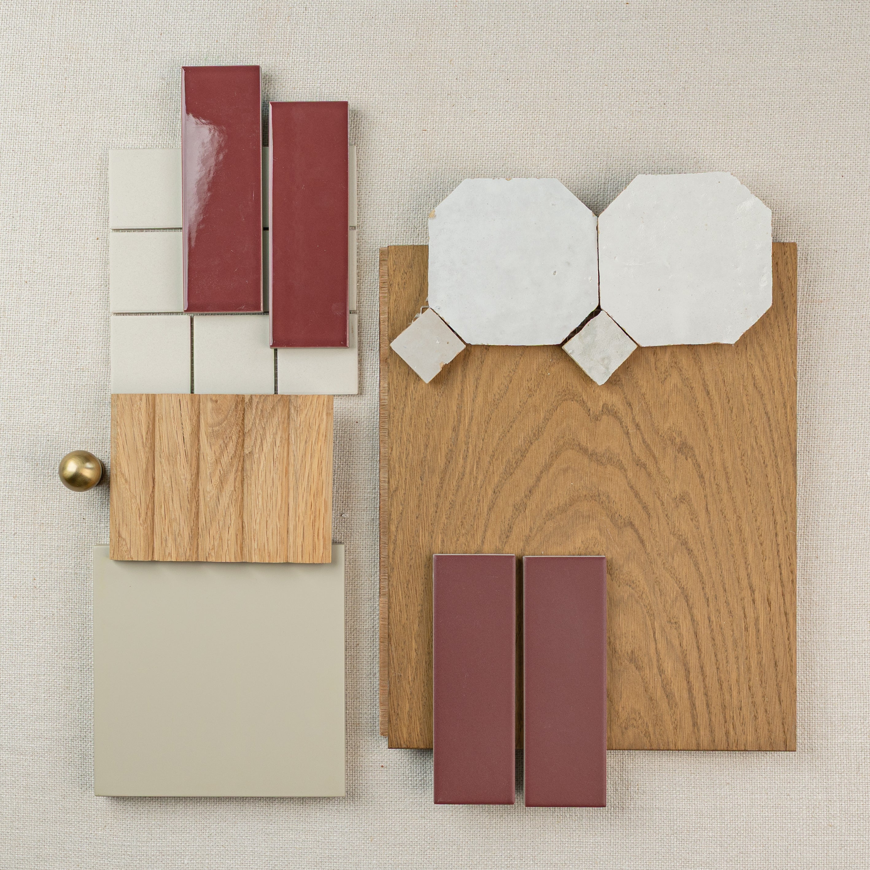Assorted wood samples and ceramic tiles in neutral and terracotta tones arranged on a fabric background