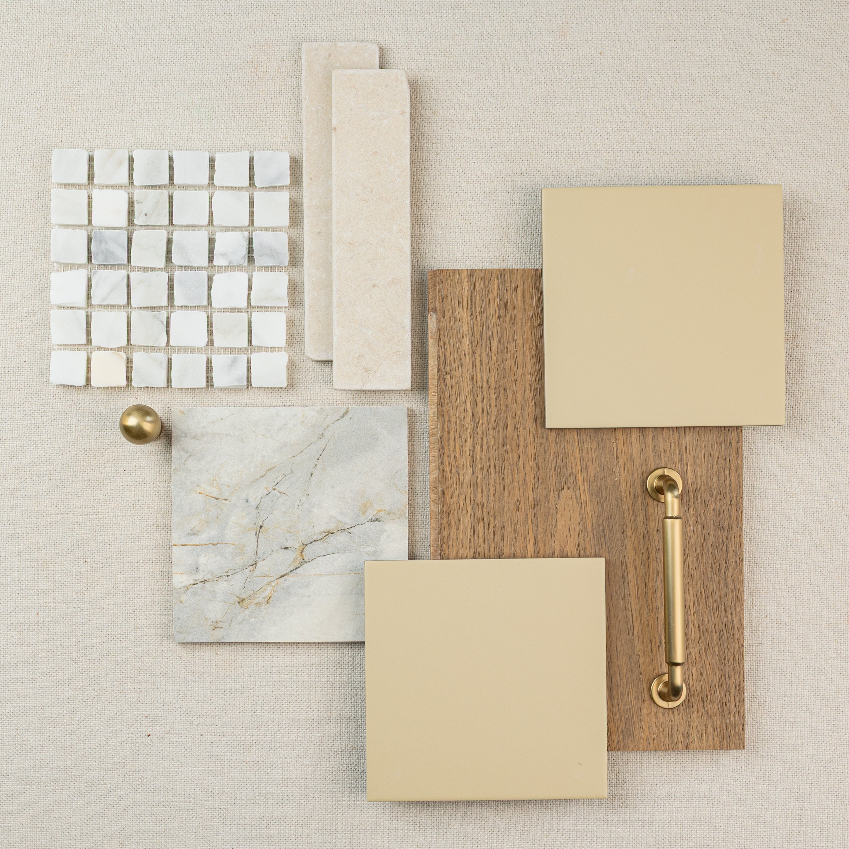 Flat lay of beige and wood tile samples with marble and gold hardware on neutral background