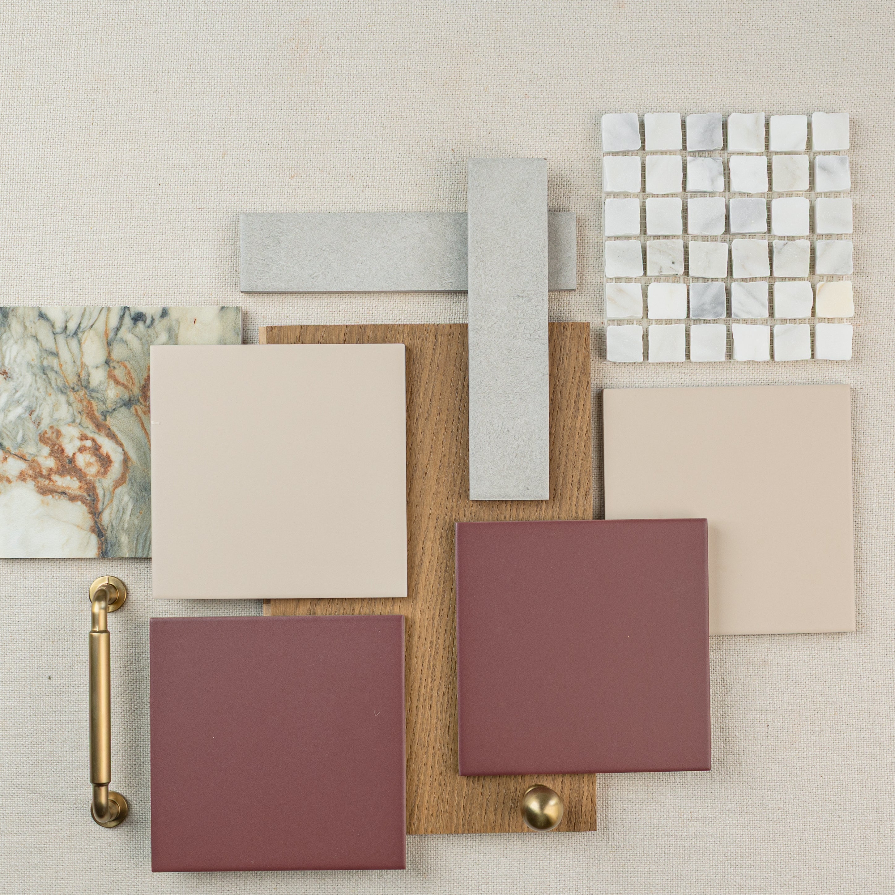 Collection of ceramic tiles, wood samples, and hardware in neutral and earthy tones for interior design inspiration