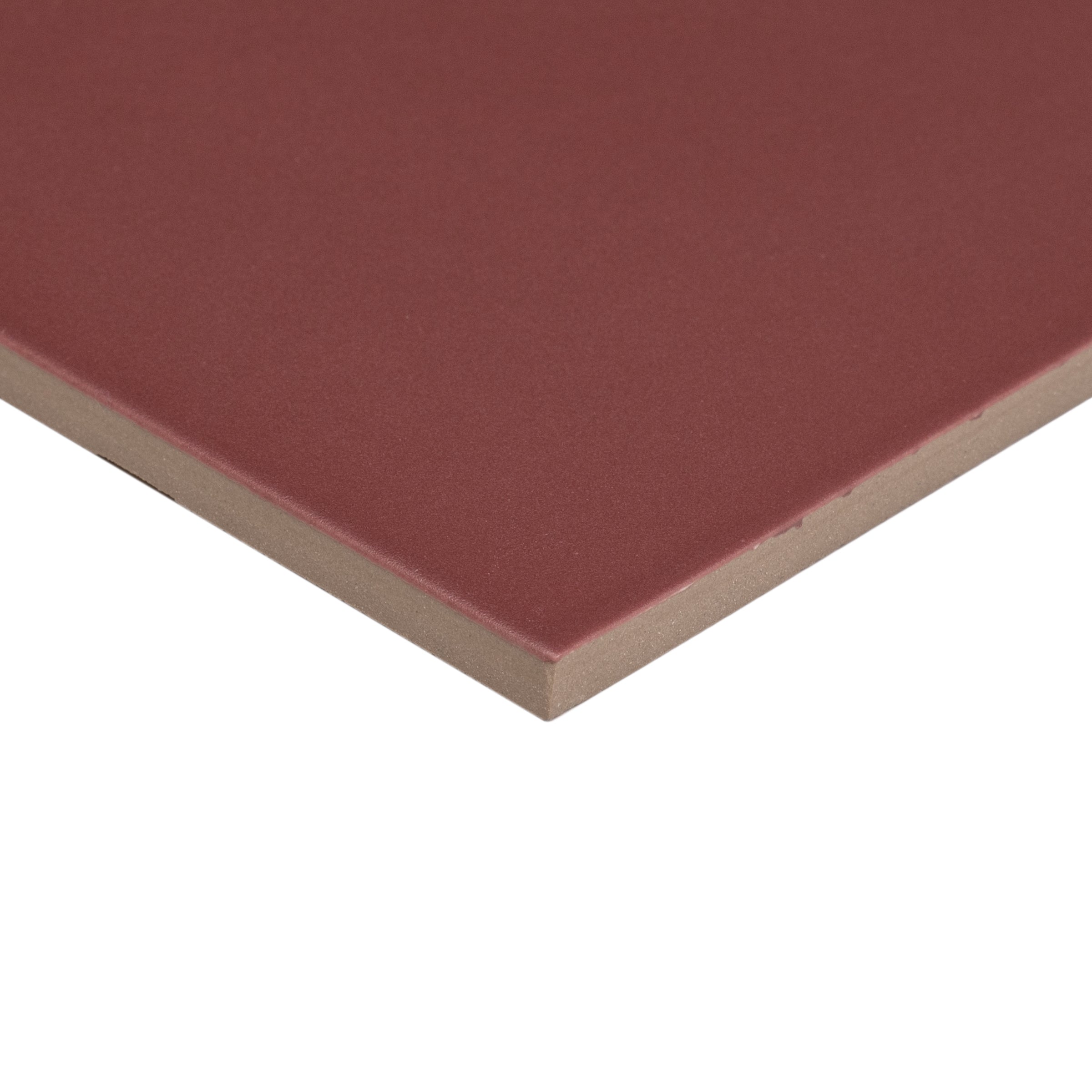 Close-up of a single deep reddish ceramic tile corner showing smooth matte surface and beige edge for flooring use