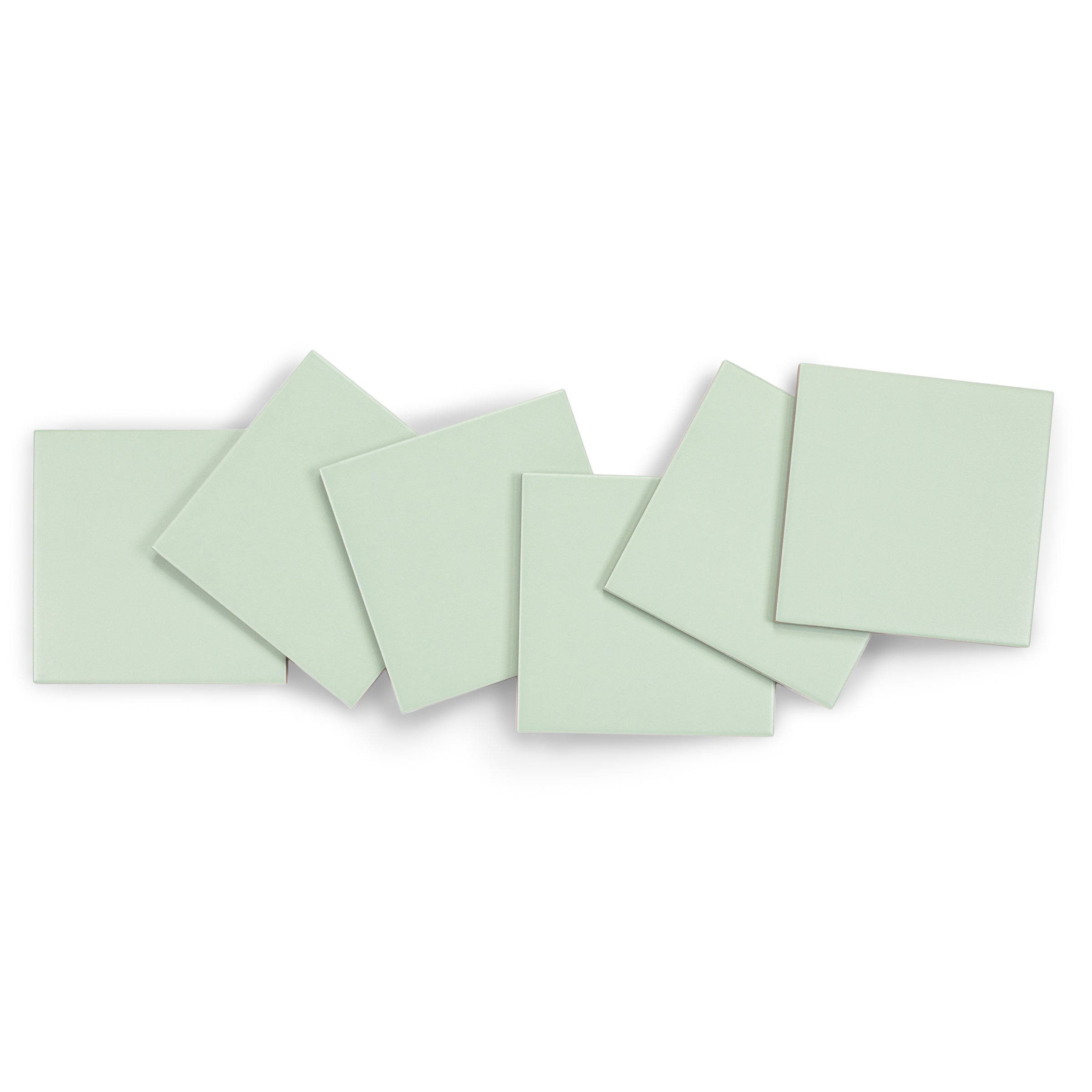 Six pale green square ceramic tiles arranged overlapping on a white background
