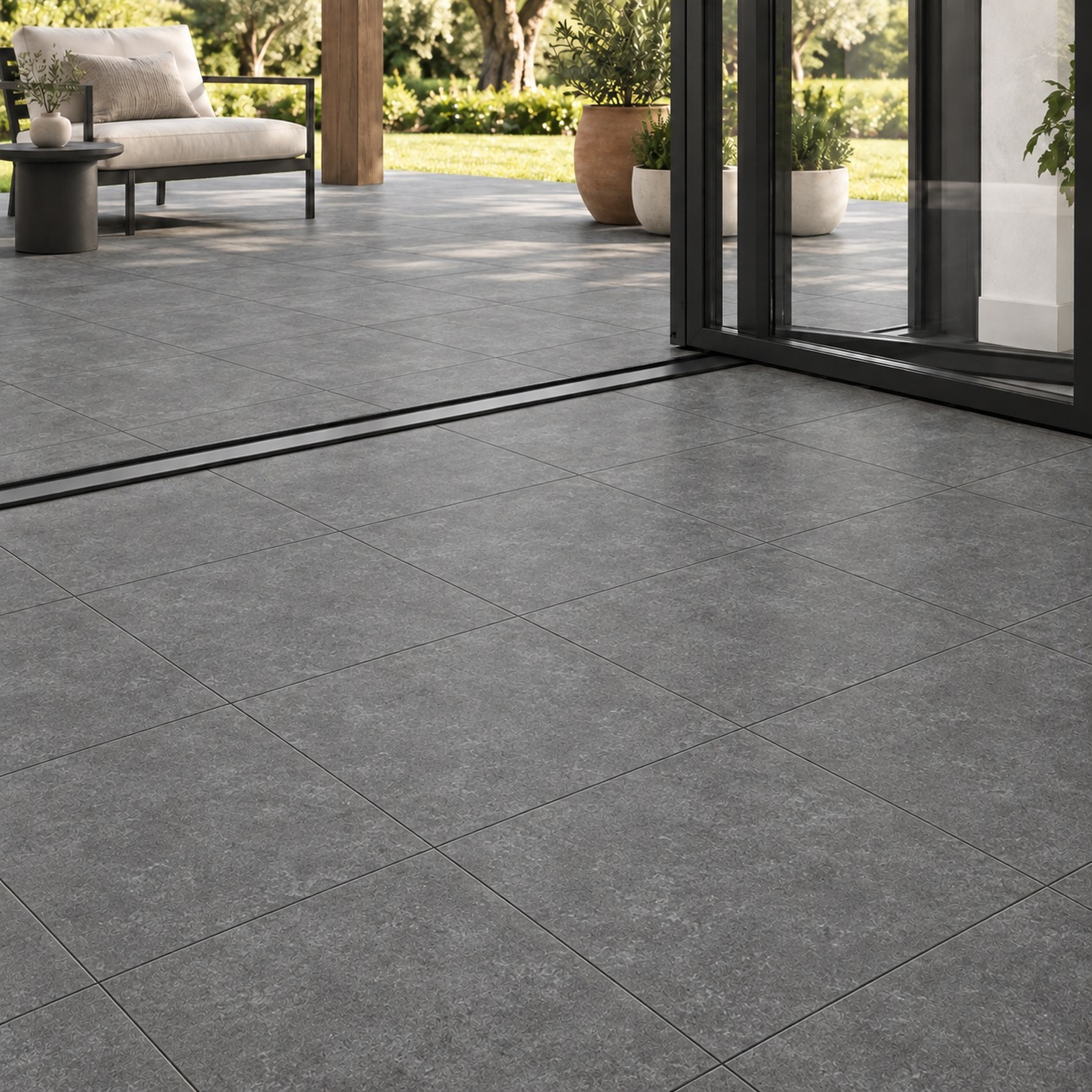 Gray tiled flooring extending from a modern interior to an outdoor patio through glass doors