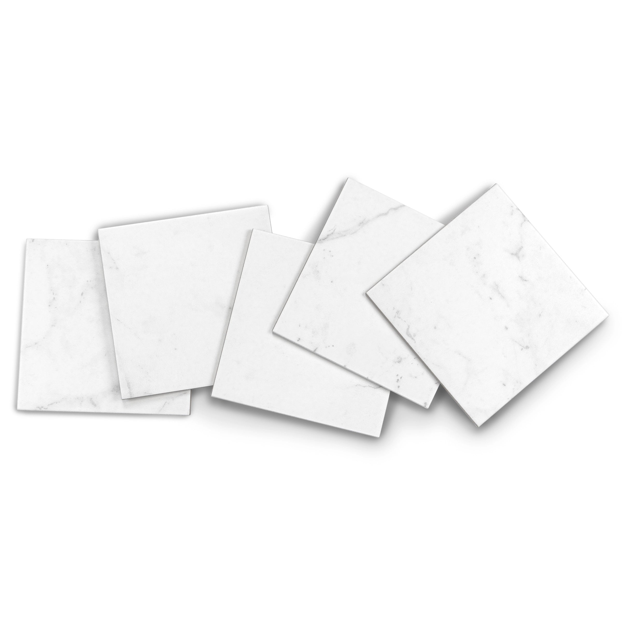 Six white square tiles with faint gray marble veining arranged casually on a white background