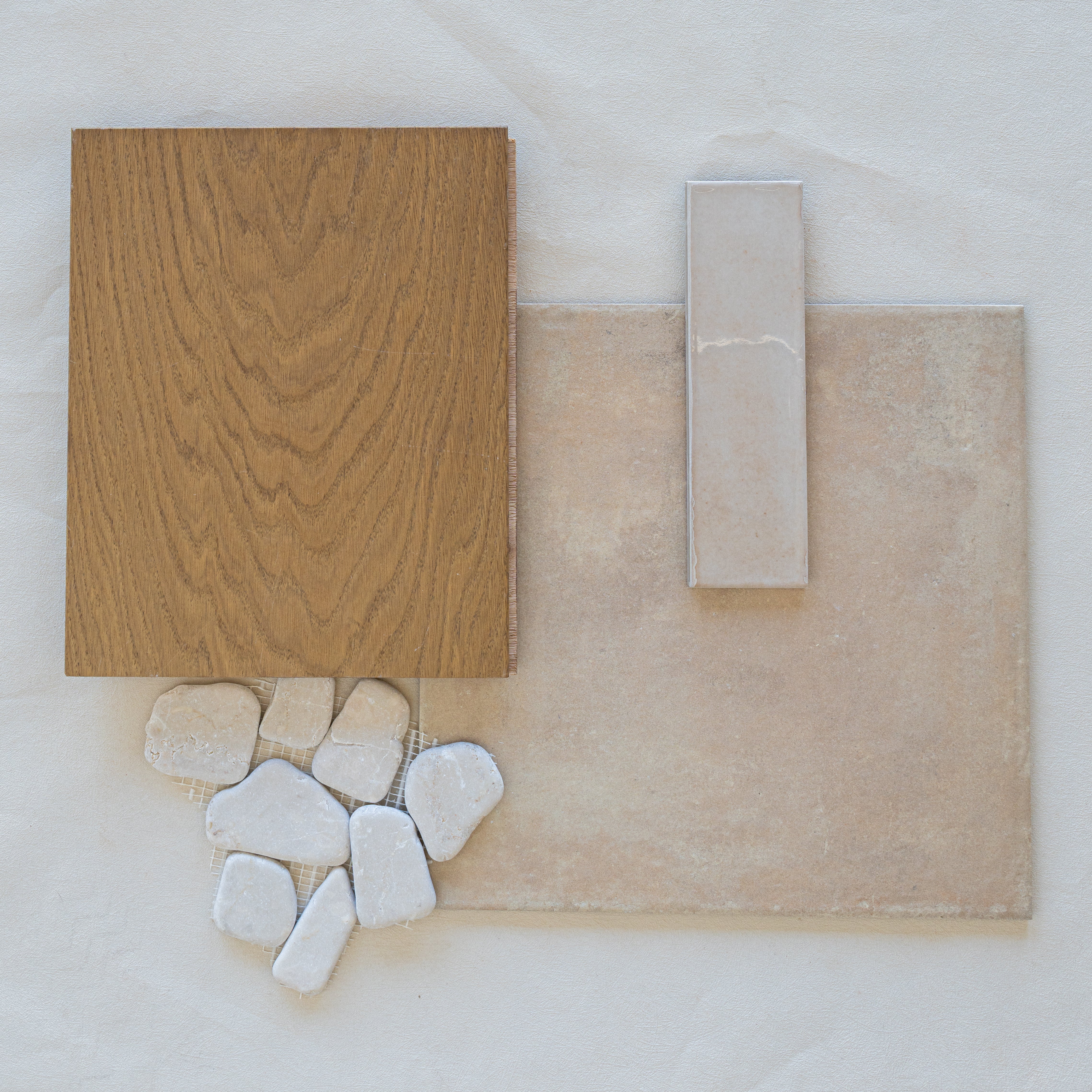 Natural oak wood plank, beige large-format tile, rectangular porcelain tile, and white irregular ceramic pieces on neutral background