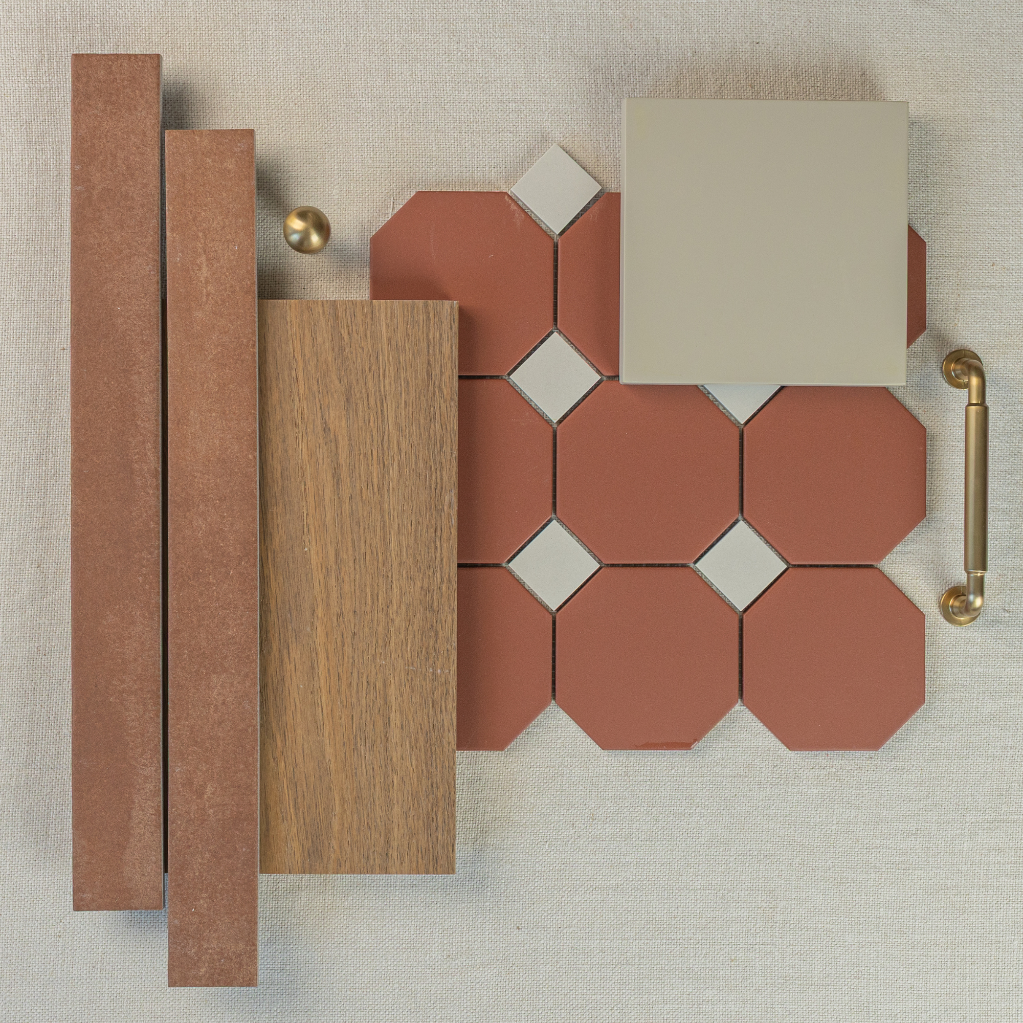 Flat lay of terracotta octagon tiles with cream ceramic square accents, oak wood sample, bronze knobs, and beige textured background