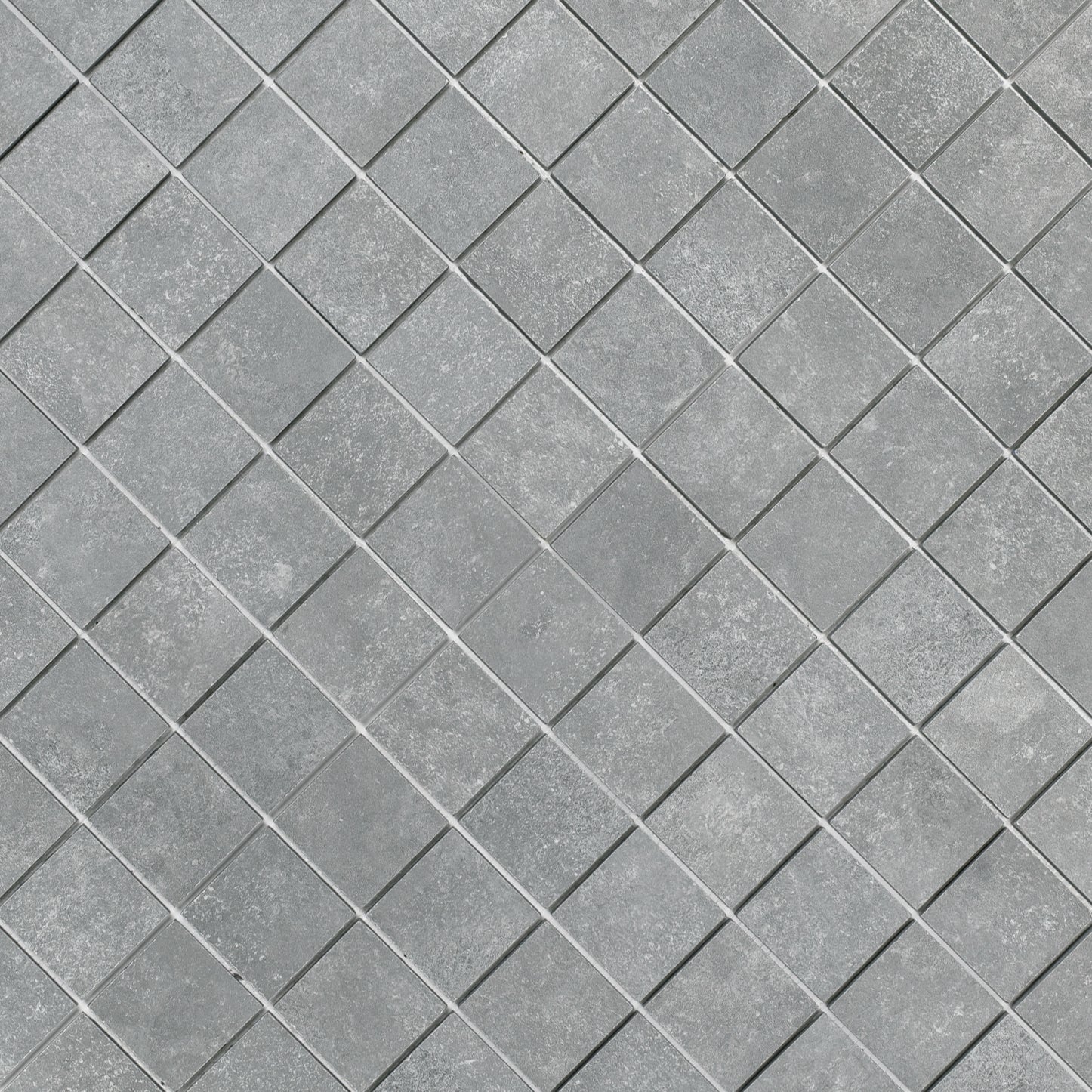 Close-up of gray porcelain mosaic tiles with a textured cement-look surface arranged in a diamond pattern