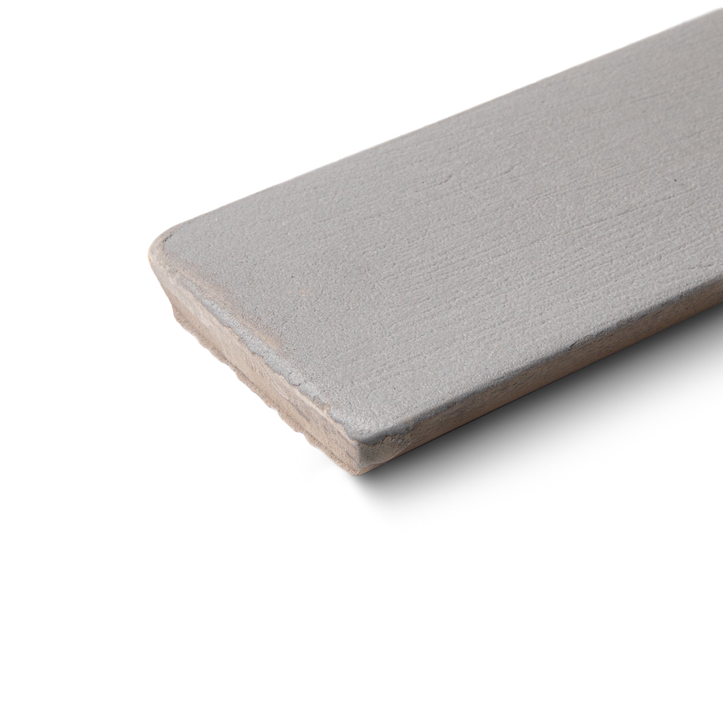 Single elongated ceramic tile in muted grey with a matte surface and softly textured, slightly rounded edges on white background