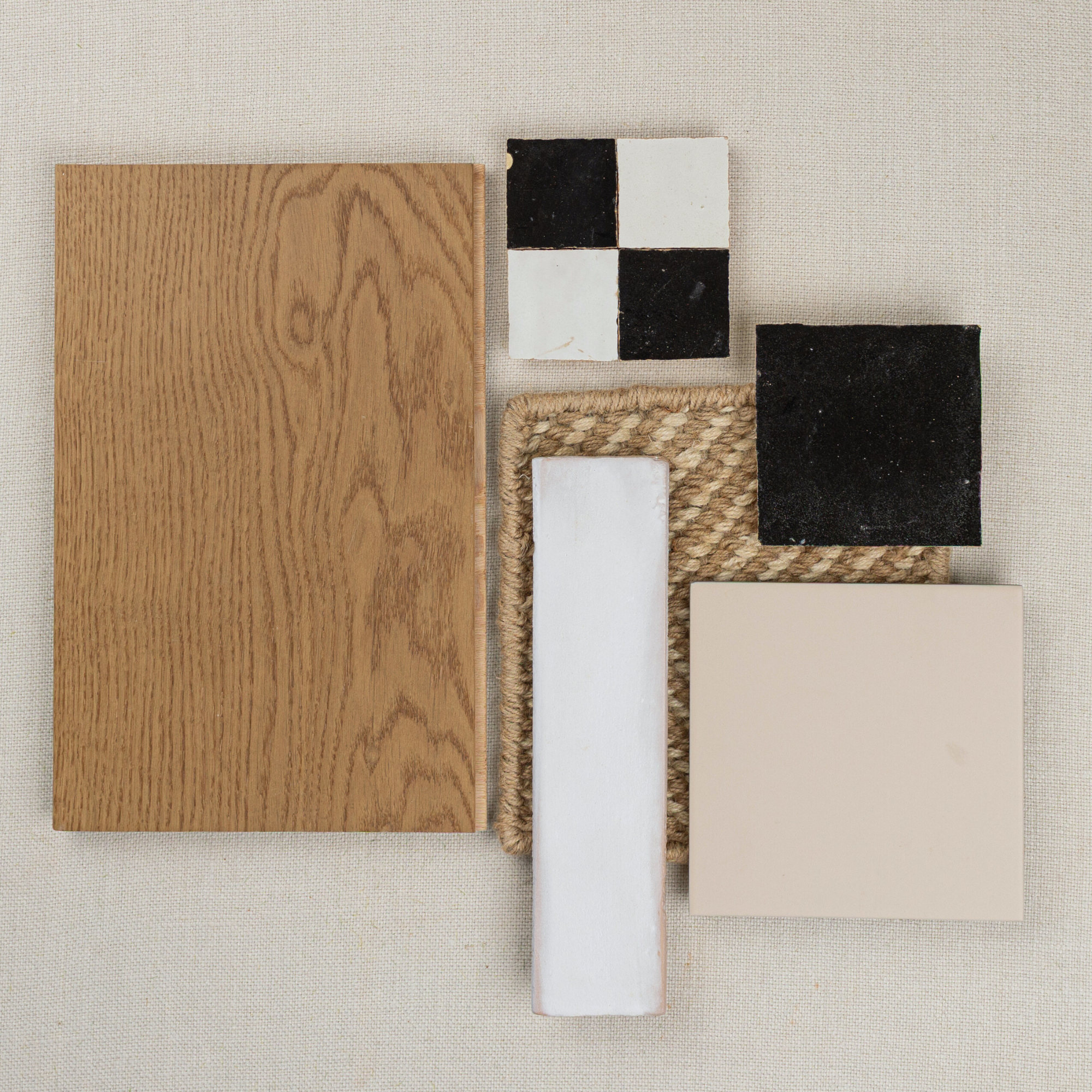 Flat lay of oak wood sample, black and white ceramic tiles, beige square tile, and woven textured fabric on neutral background
