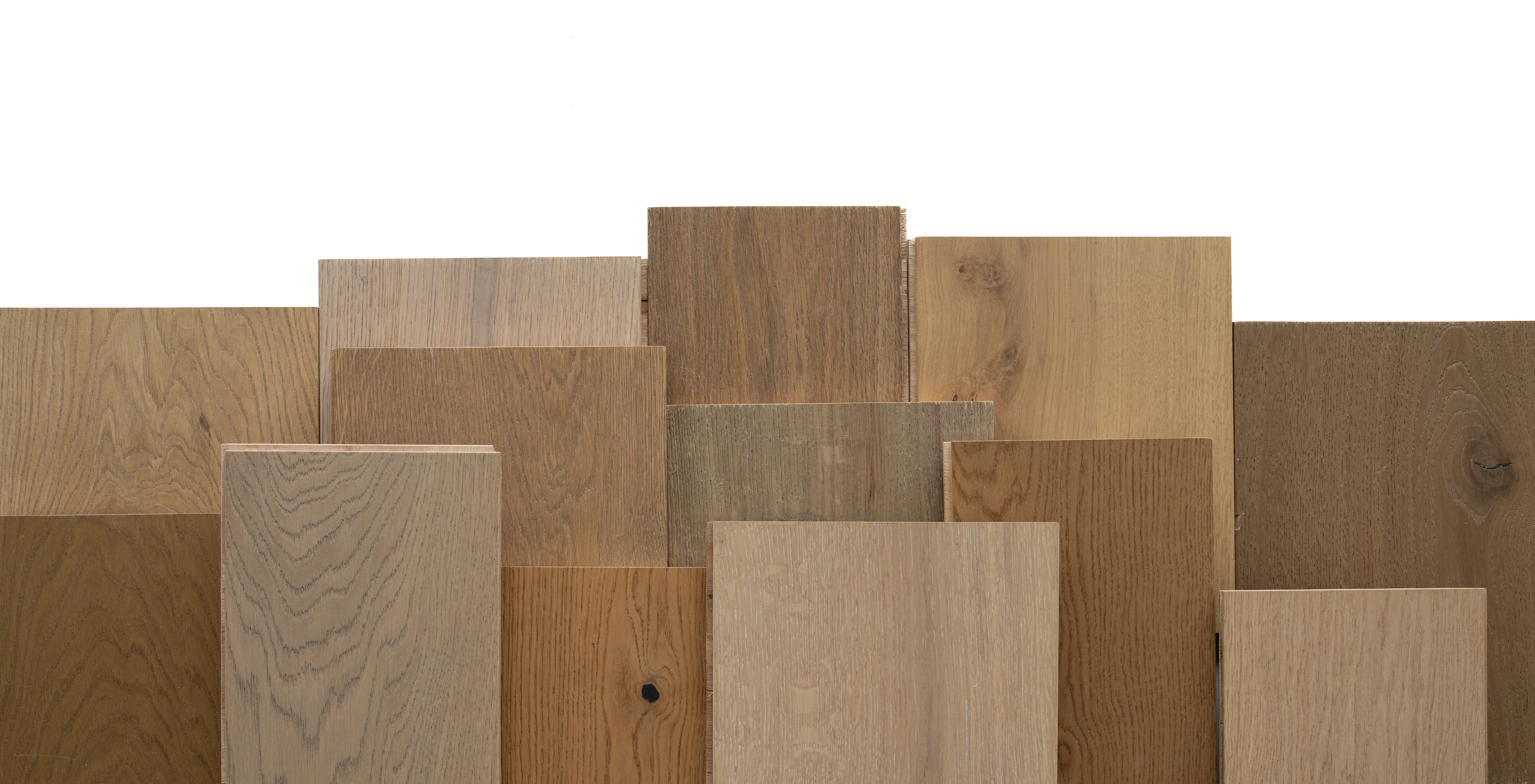 Assortment of engineered wood planks in varied natural oak tones arranged overlapping on white background