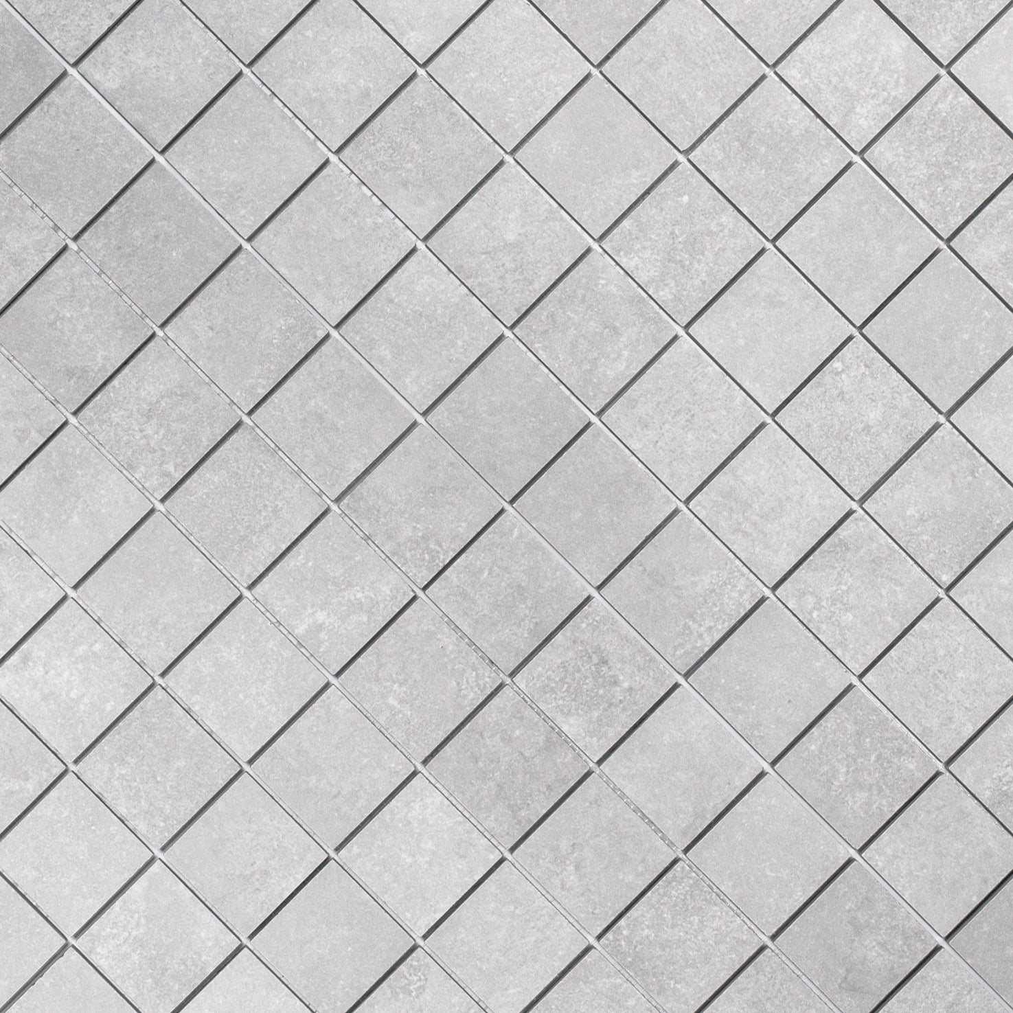 Close-up of light gray porcelain tiles arranged diagonally with a subtle textured surface and thin grout lines