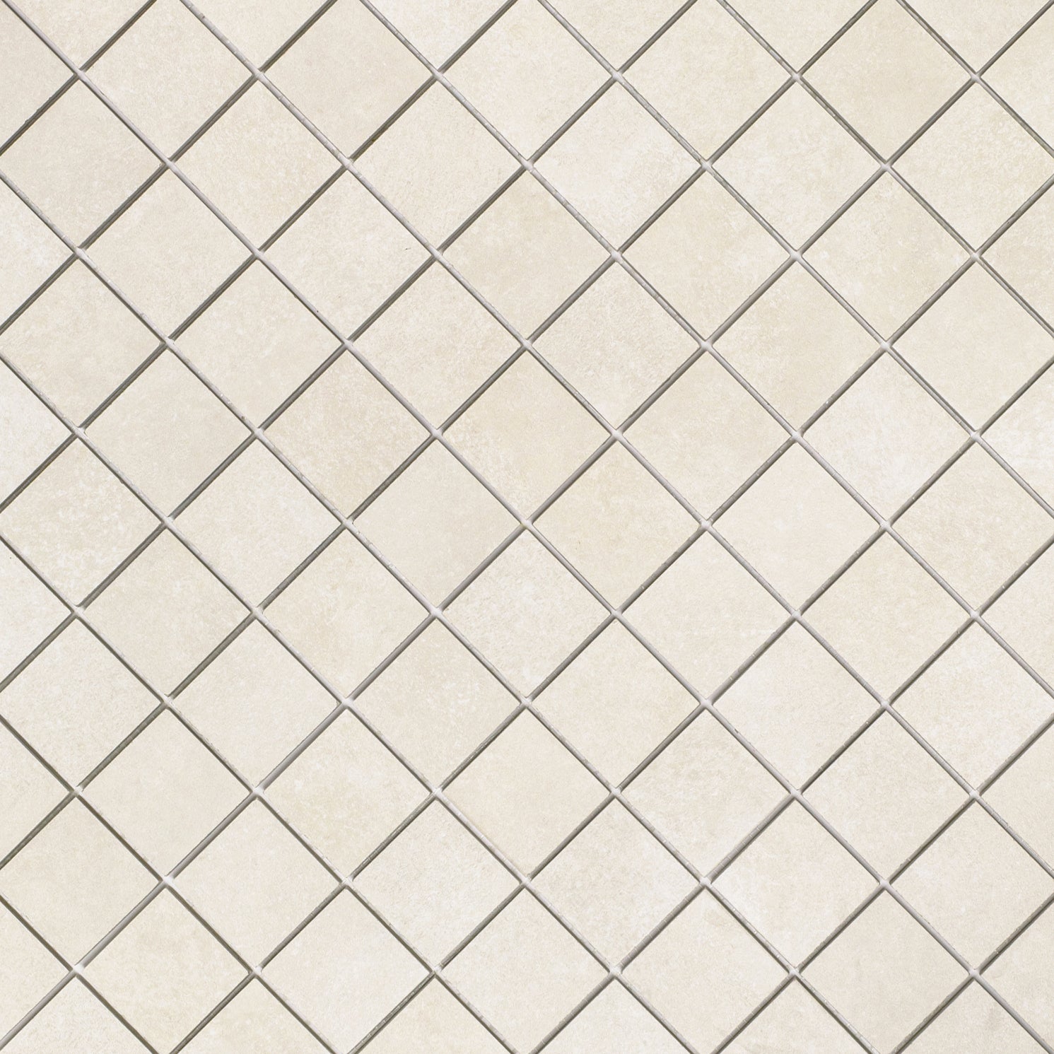 Close-up of diamond-patterned ceramic tiles in soft almond tones with subtle texture and fine grout lines