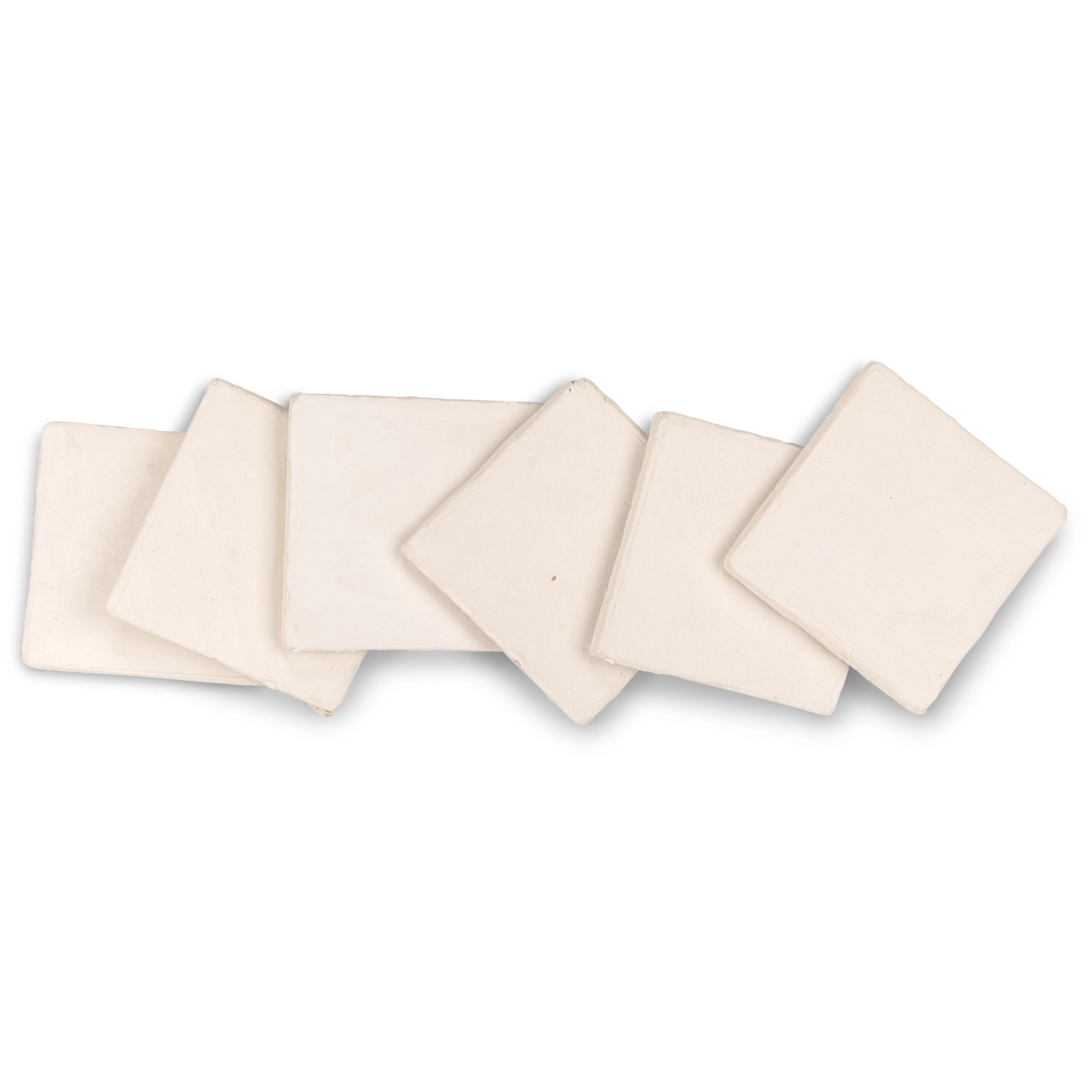 Set of six creamy off-white ceramic tiles with soft, uneven edges arranged loosely on white background