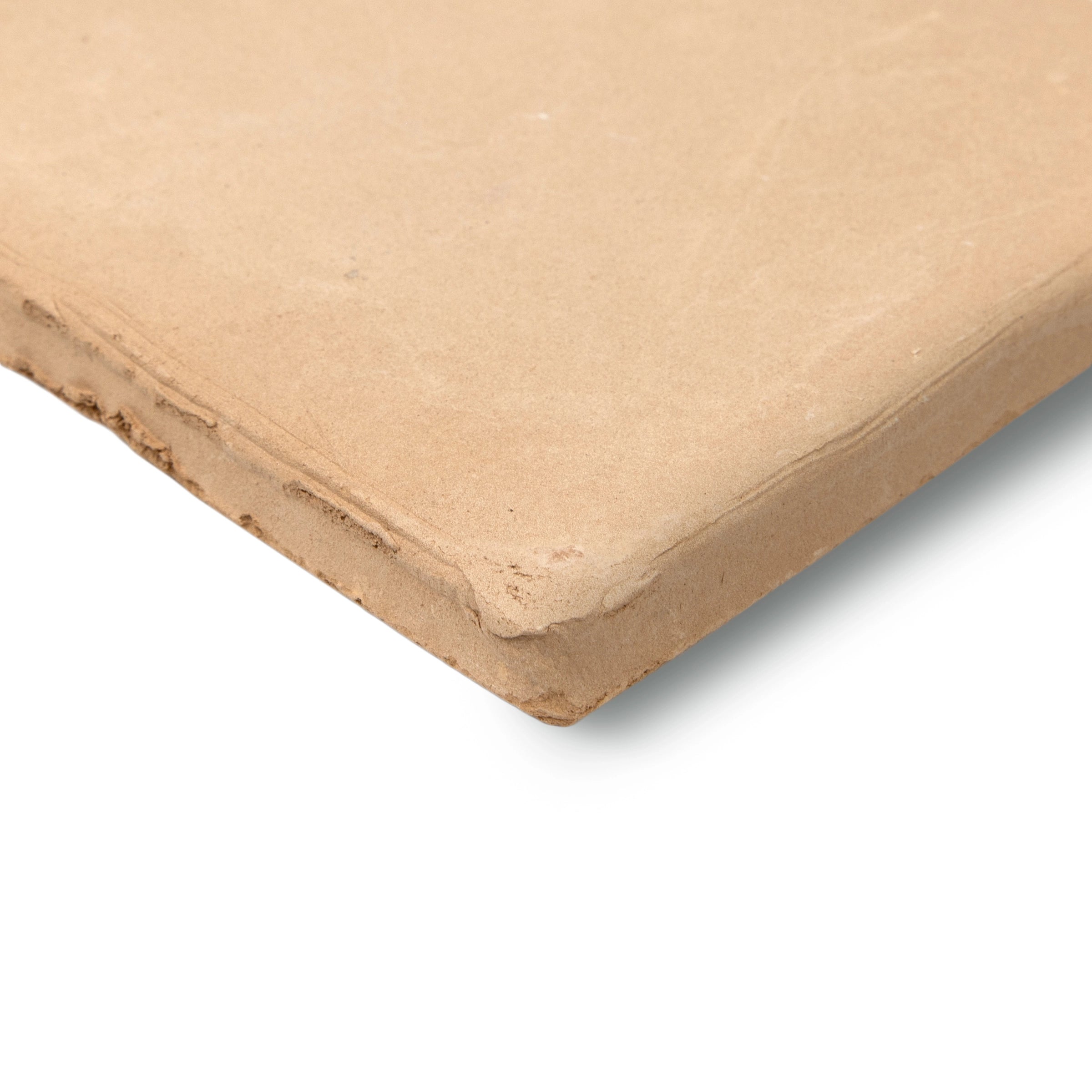 Close-up of a single warm beige terracotta tile with natural rough edges and matte finish for rustic flooring designs