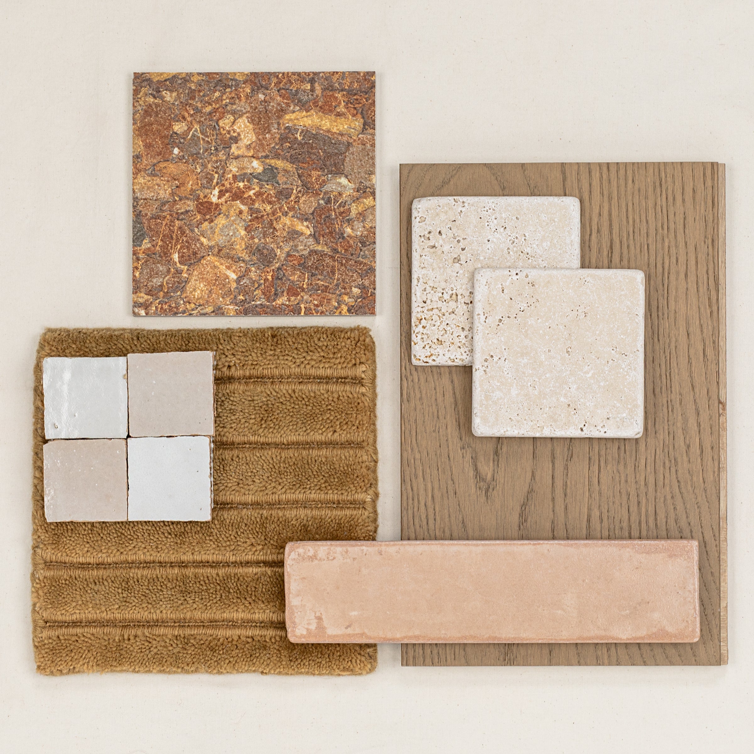 Collection of textured stone and ceramic tile samples paired with warm wood and soft brown fabric swatch