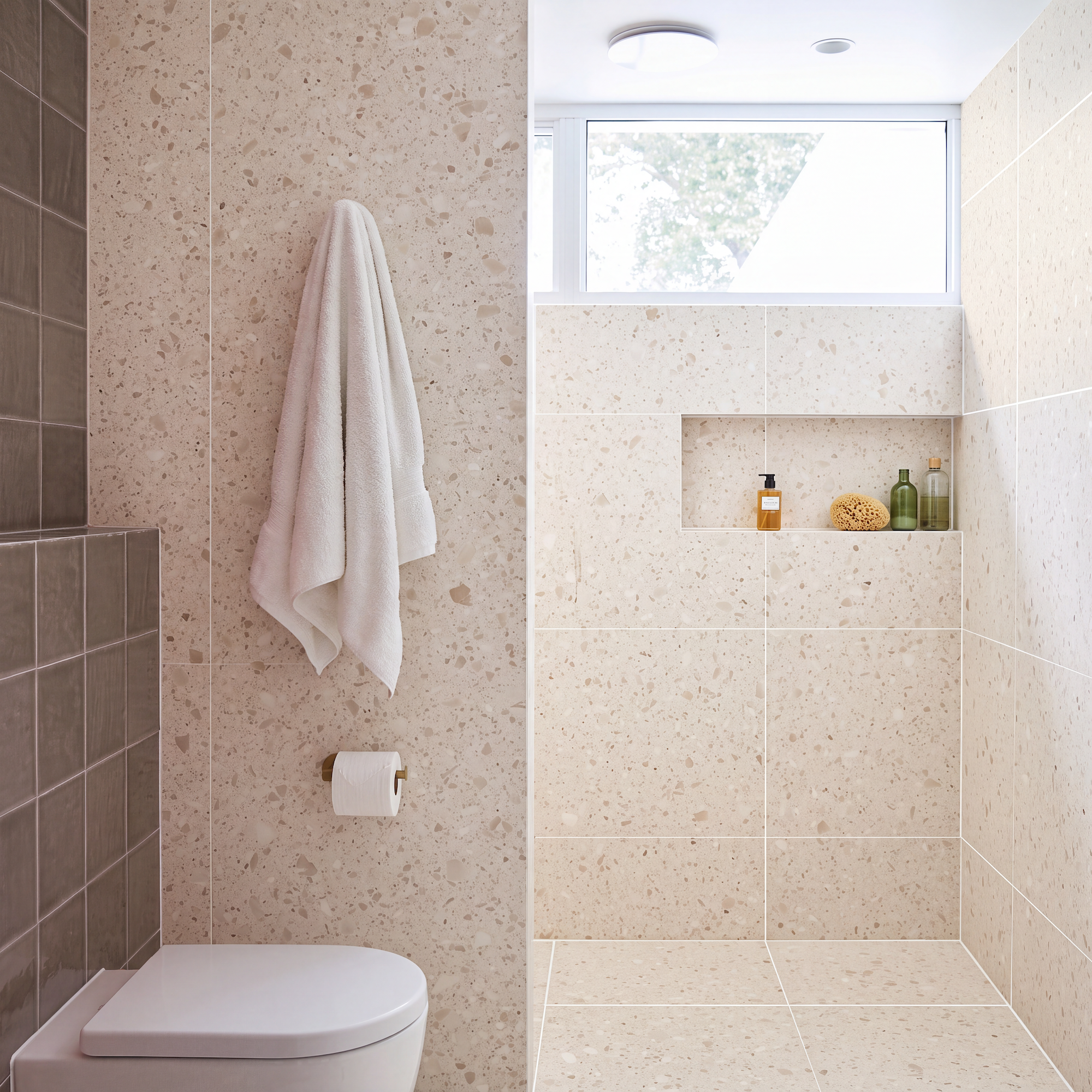 Bathroom with beige terrazzo tile walls and floor walk-in shower toilet and white towel
