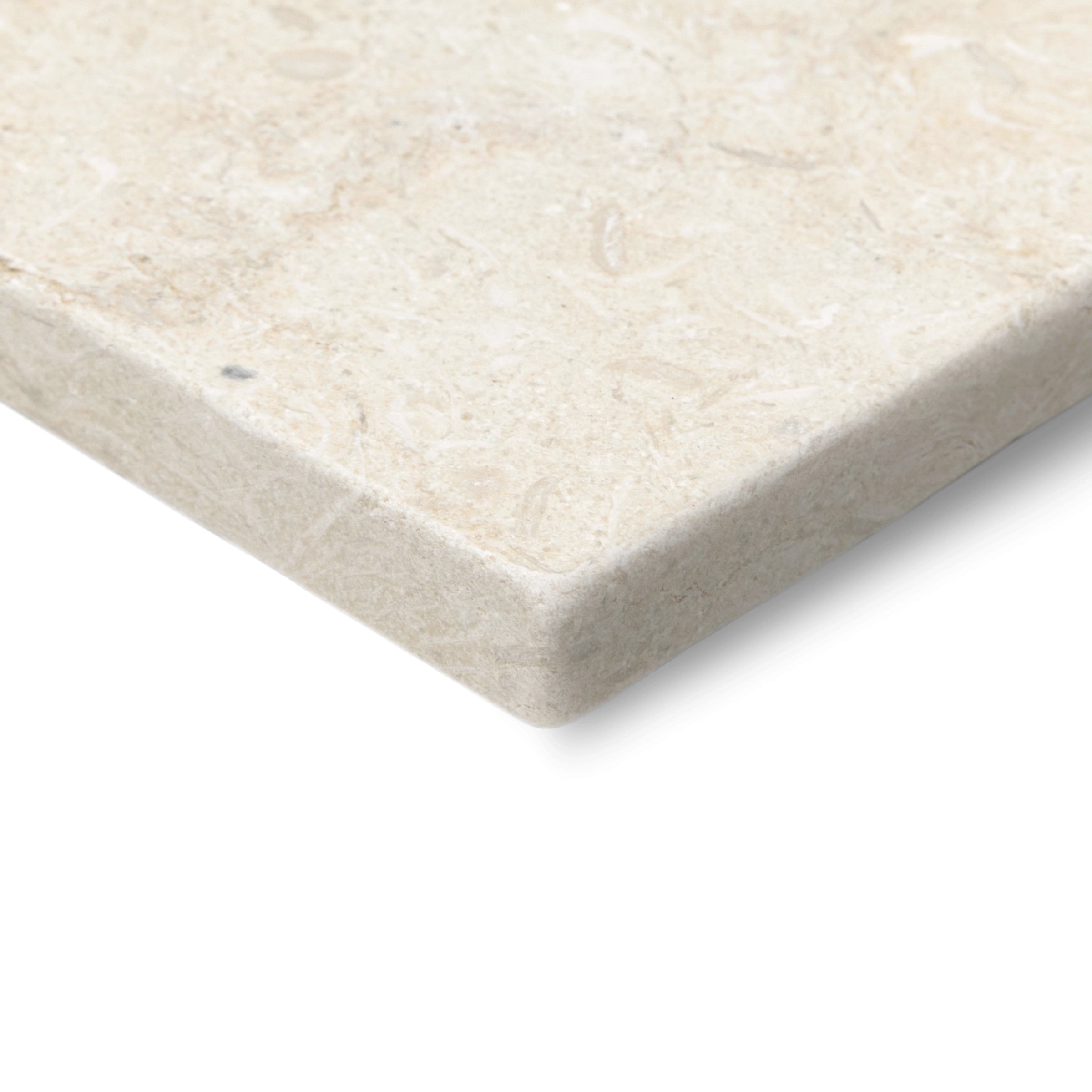 Close-up of a beige stone tile corner with smooth edges and subtle fossilized texture on a white background