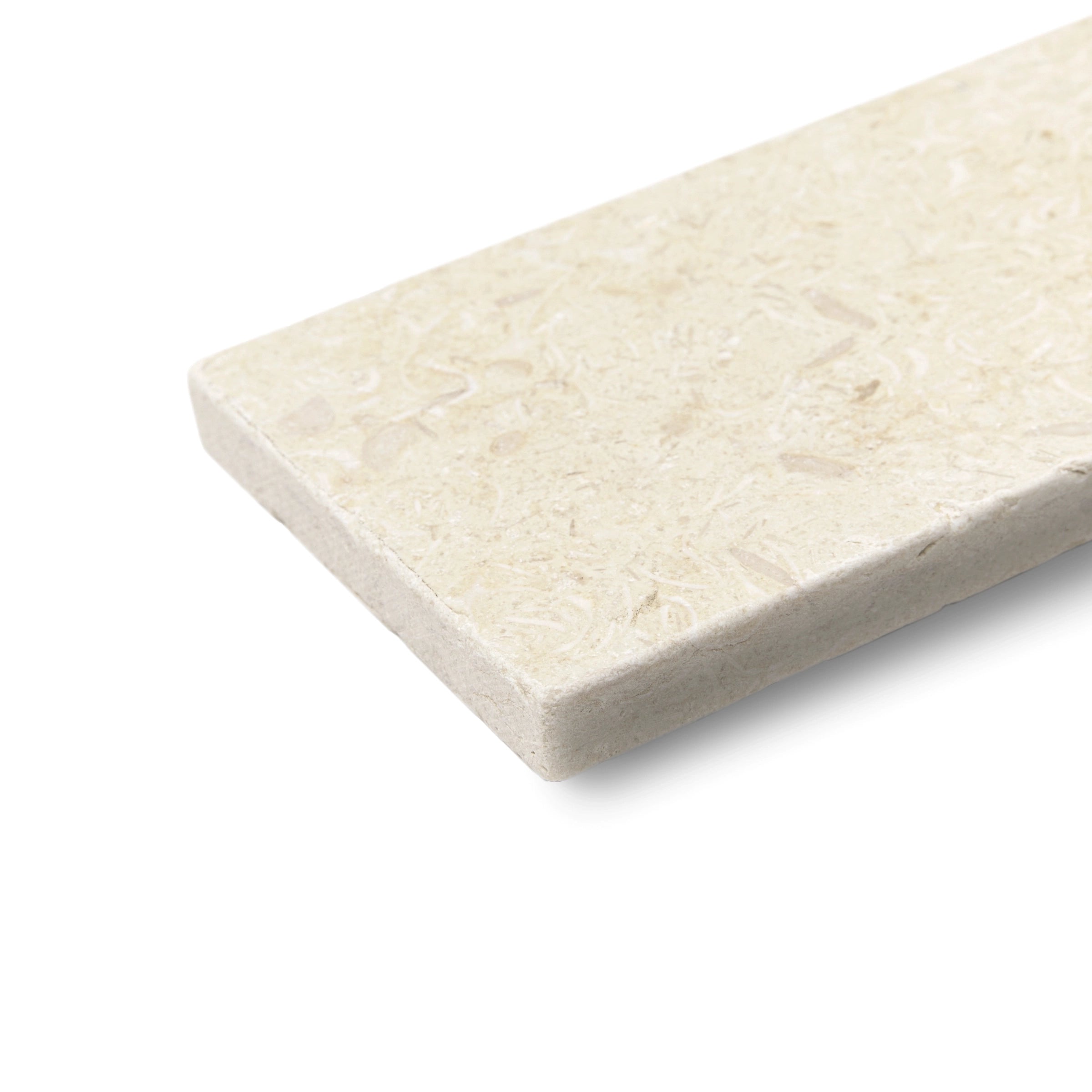 Close-up of a rectangular cream stone tile with subtle fossilized texture and slightly rough tumbled edges on white background