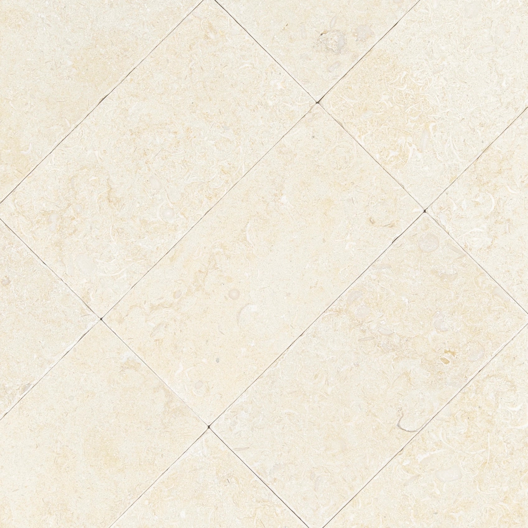 Diagonal arrangement of cream-colored stone tiles with subtle fossilized patterns and natural texture on the surface