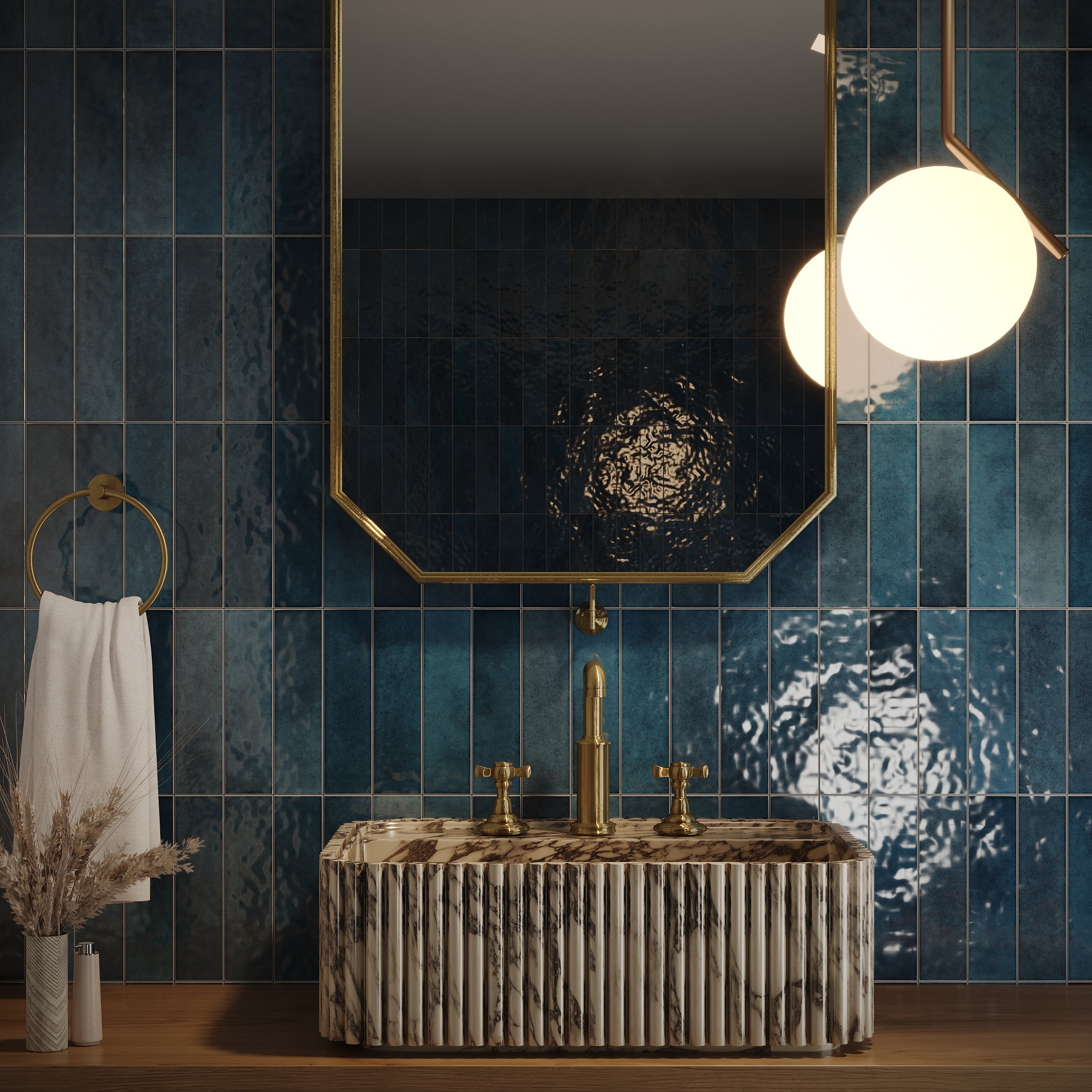 Glossy deep blue ceramic tiles with subtle texture surrounding a gold-framed mirror and marble sink with gold fixtures
