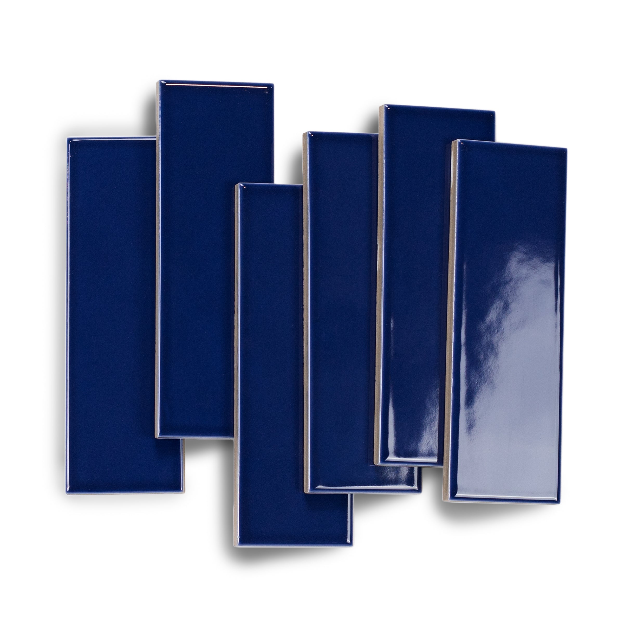 Glossy rectangular porcelain tiles in rich ocean blue with smooth surfaces and sharp edges arranged overlap on white background