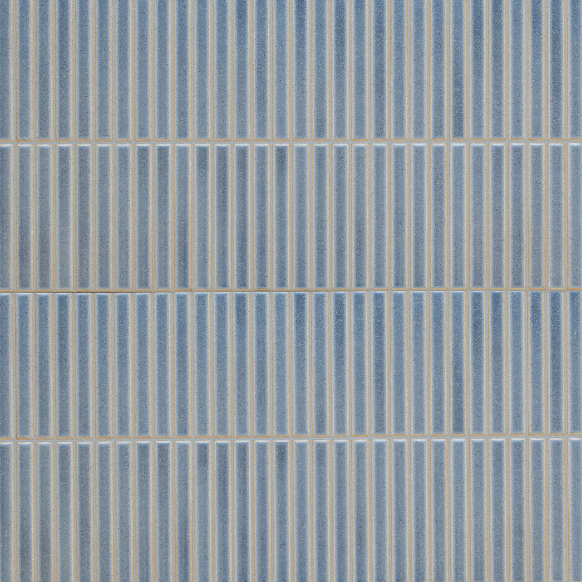 Vertical rectangular blue ceramic tiles arranged with narrow beige grout lines in a clean, modern pattern