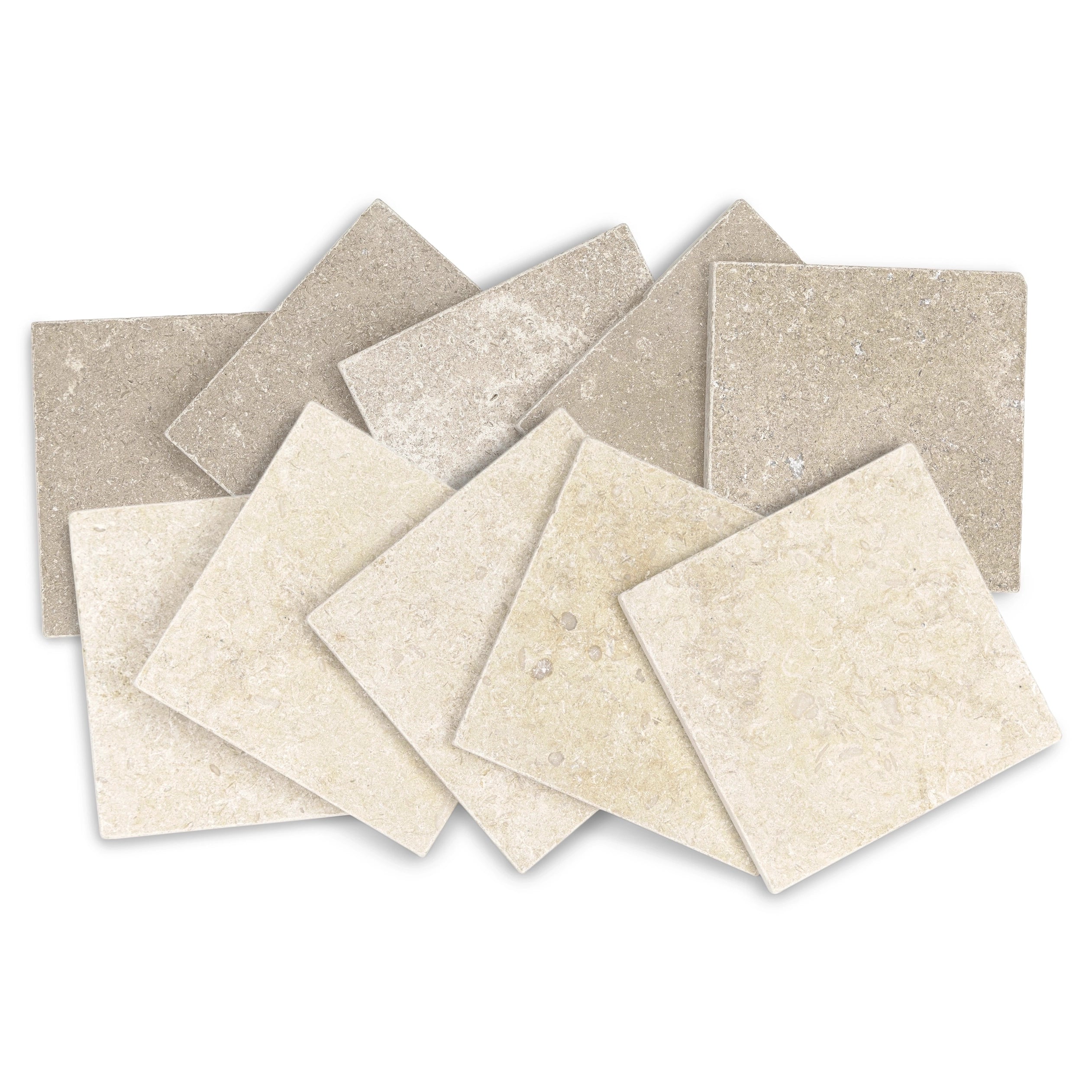 Pile of beige and light taupe square stone tiles with natural tumbled texture and subtle mineral variations