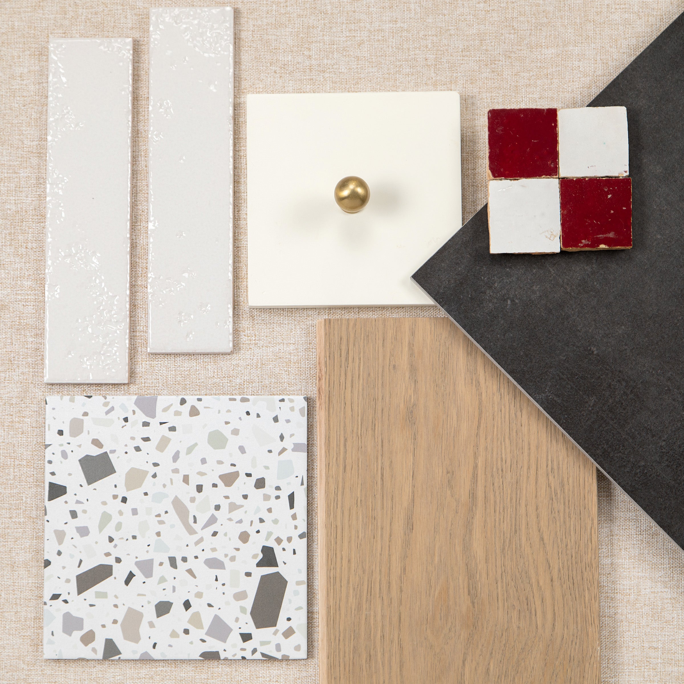Interior material samples with white tiles, terrazzo, oak flooring, dark stone, and red and white tiles