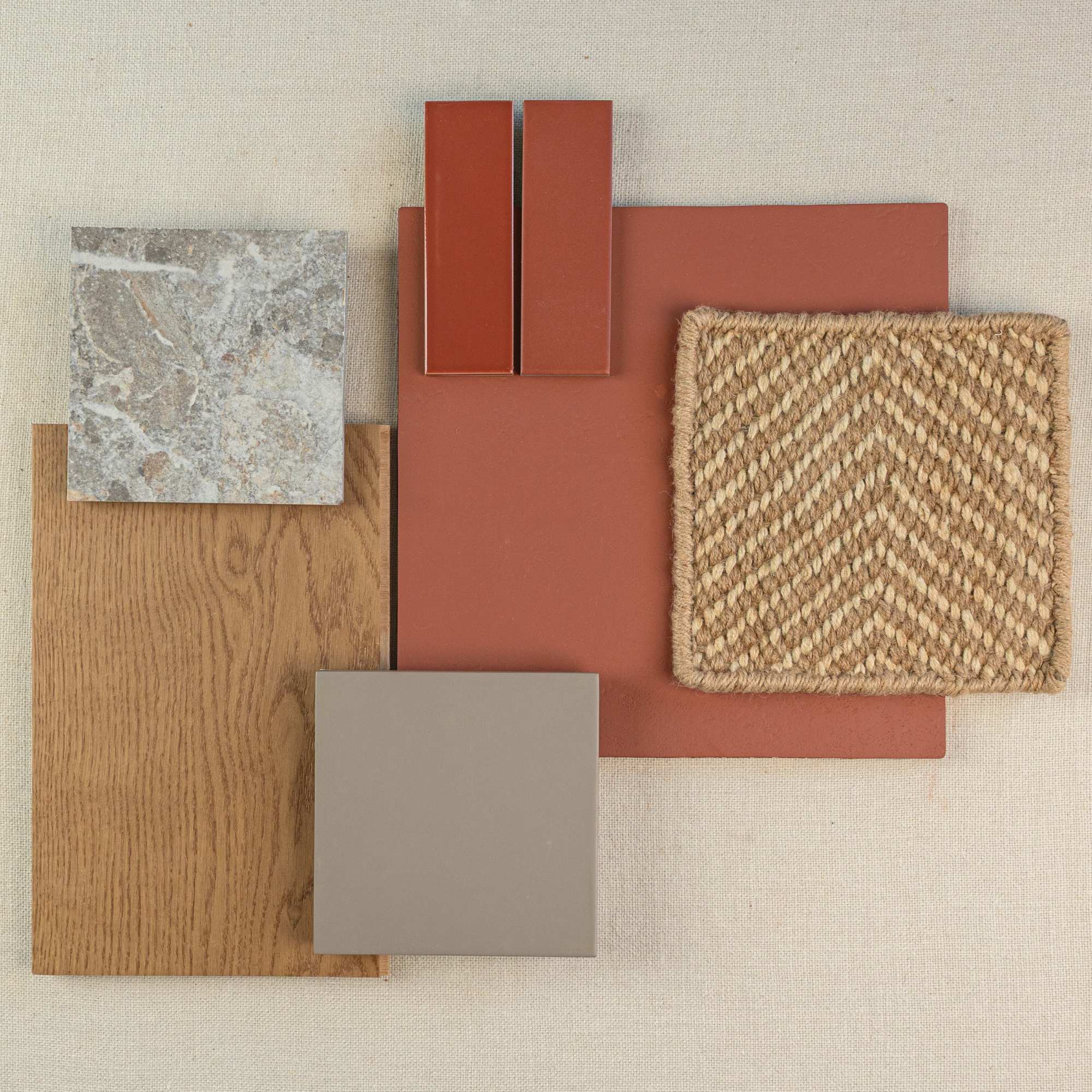 Flat lay of warm-toned tile and flooring samples including terracotta, wood plank, stone, beige ceramic, and woven texture square