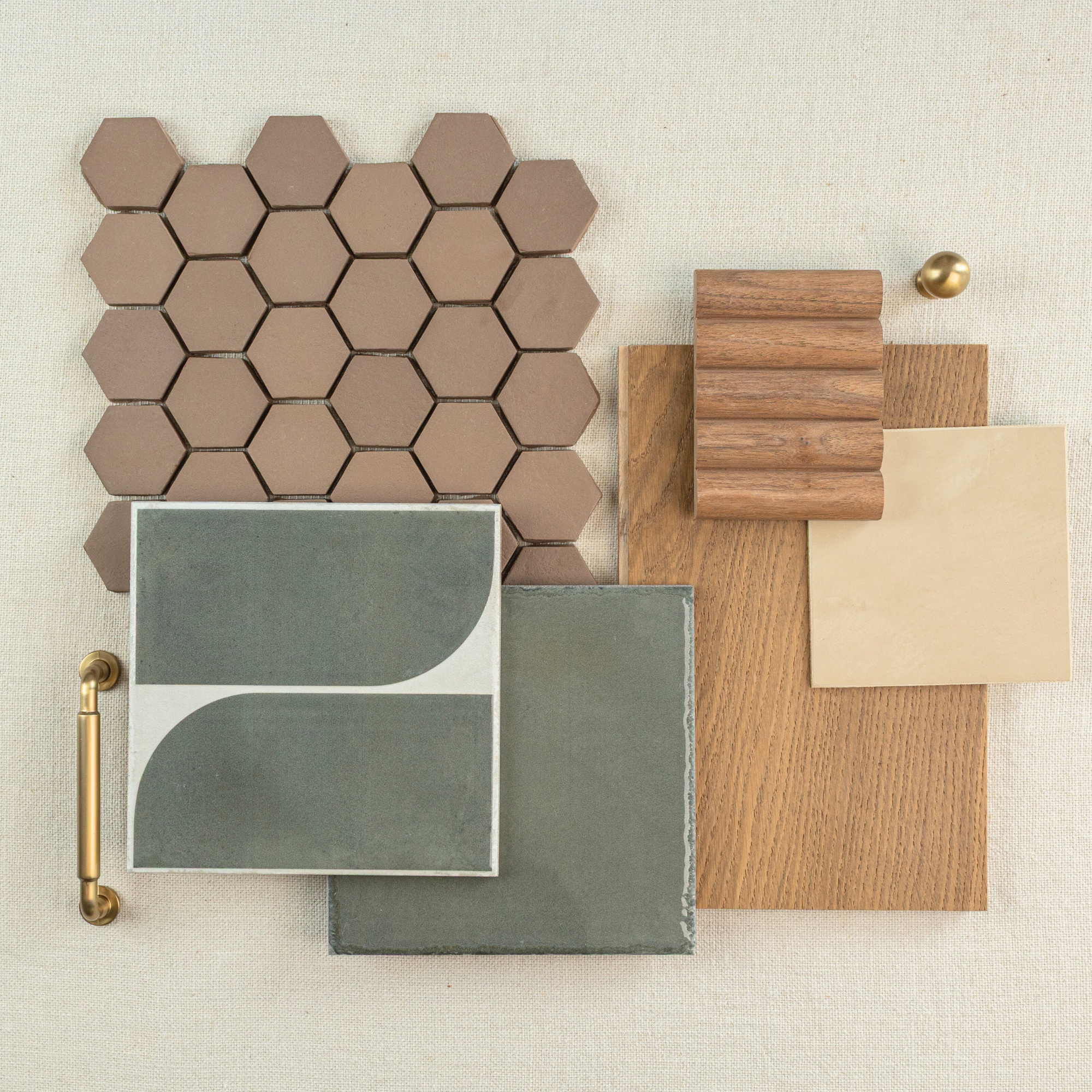 Arrangement of hexagonal beige tiles, green patterned and solid tiles, wood samples, and a brass handle on neutral background