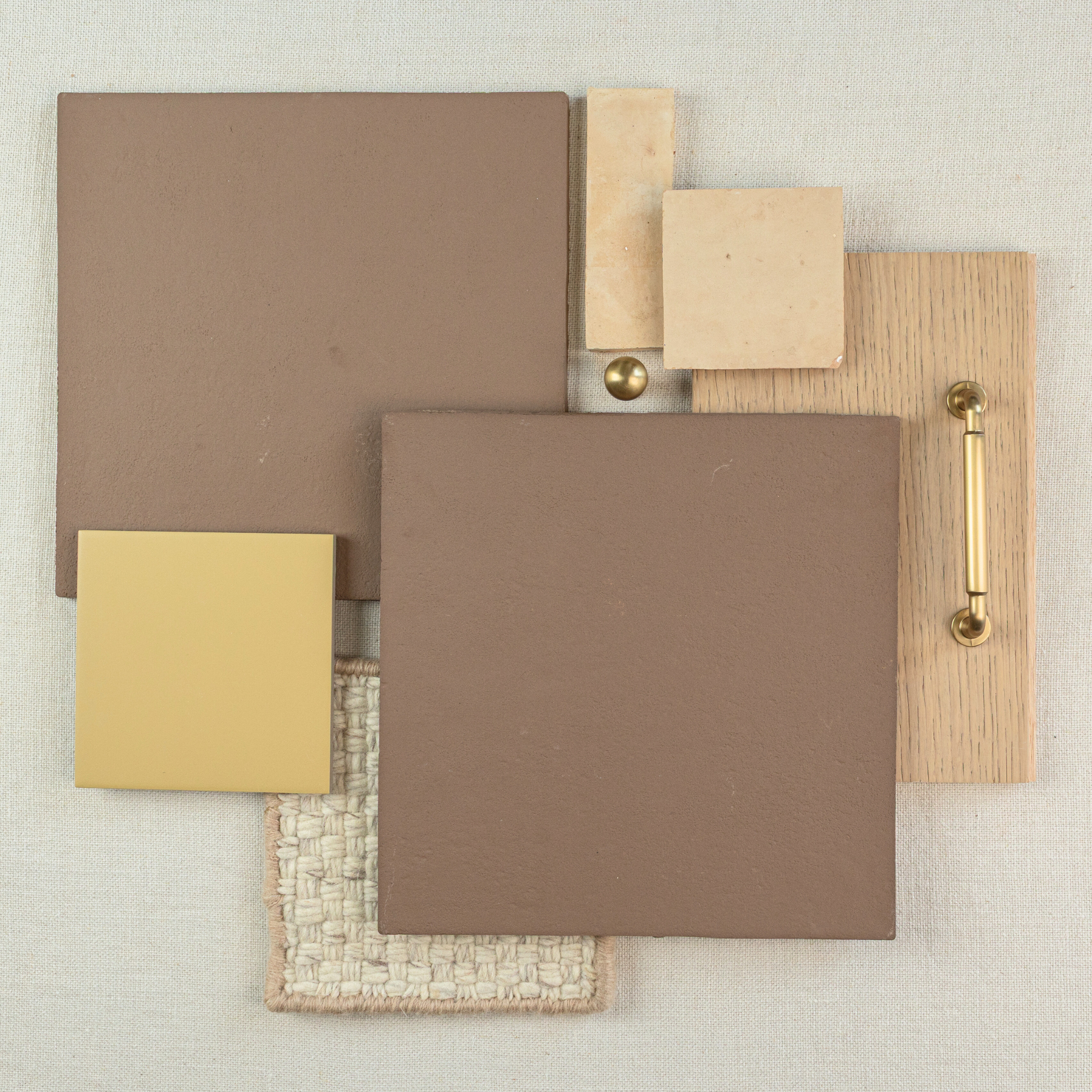 Matte brown ceramic tiles paired with beige stone squares, light oak wood with brass handle, and woven fabric swatch on neutral surface