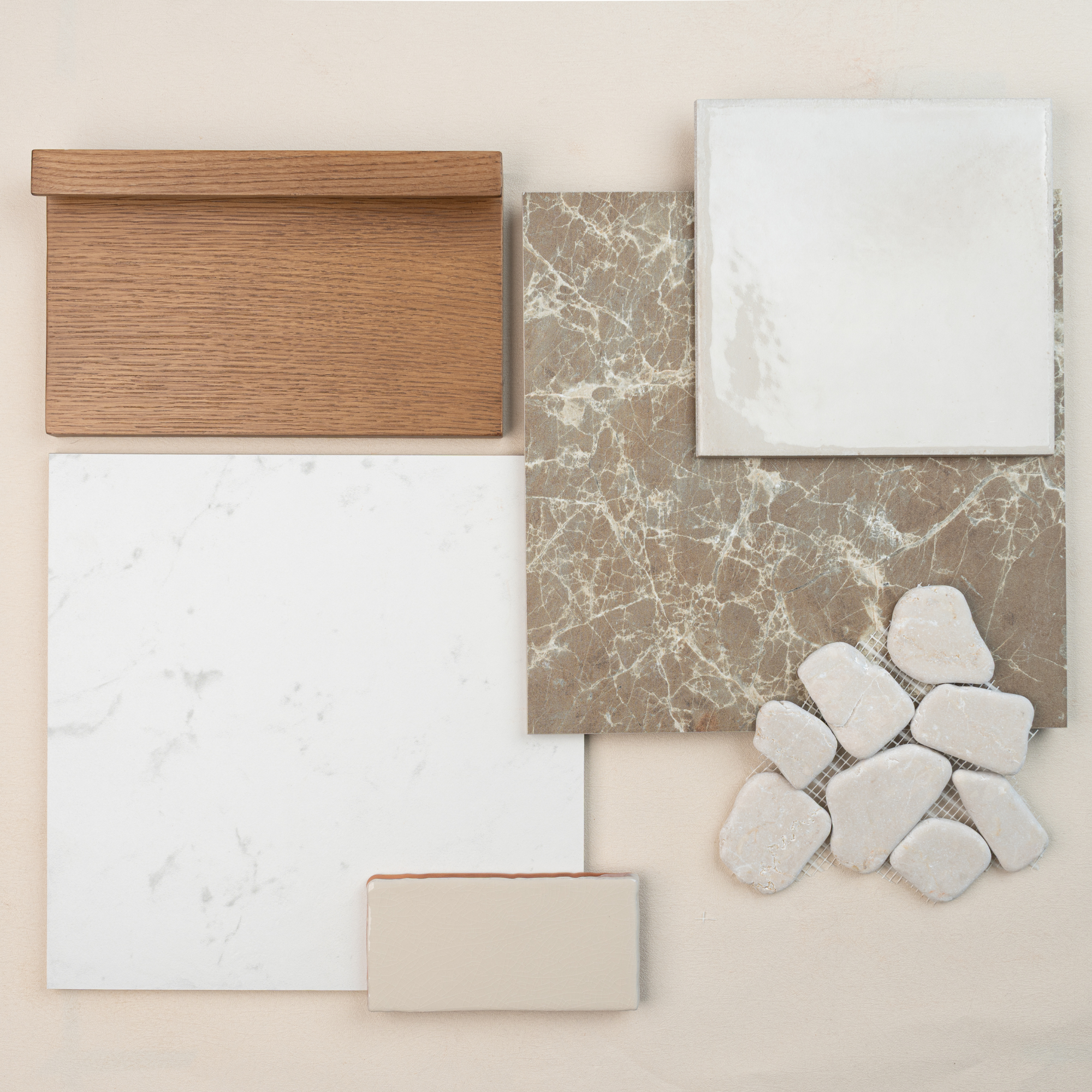 Selection of oak wood sample, beige marble tile, glossy white ceramic tile, matte white tile, and smooth white stones on pale background