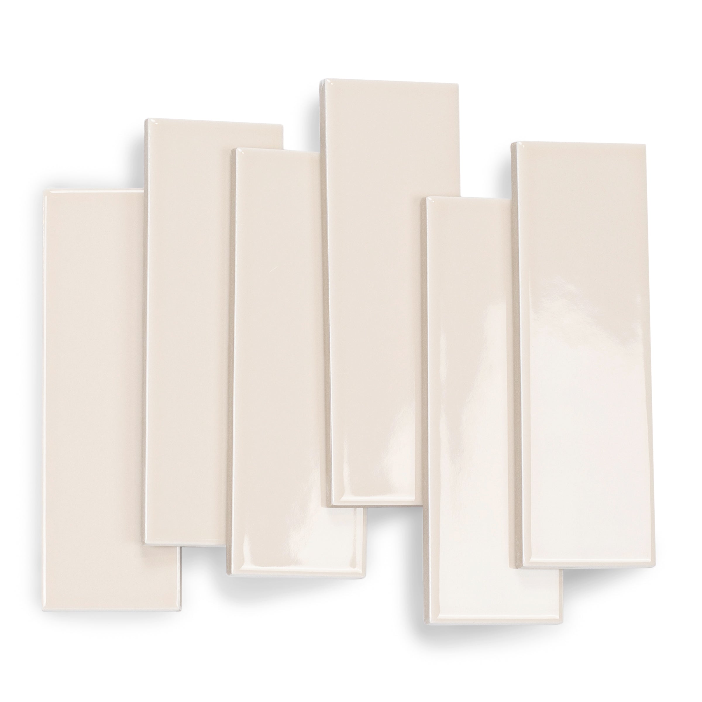 Glossy rectangular porcelain tiles in a light sand color with smooth surfaces and clean edges arranged overlapping on white background