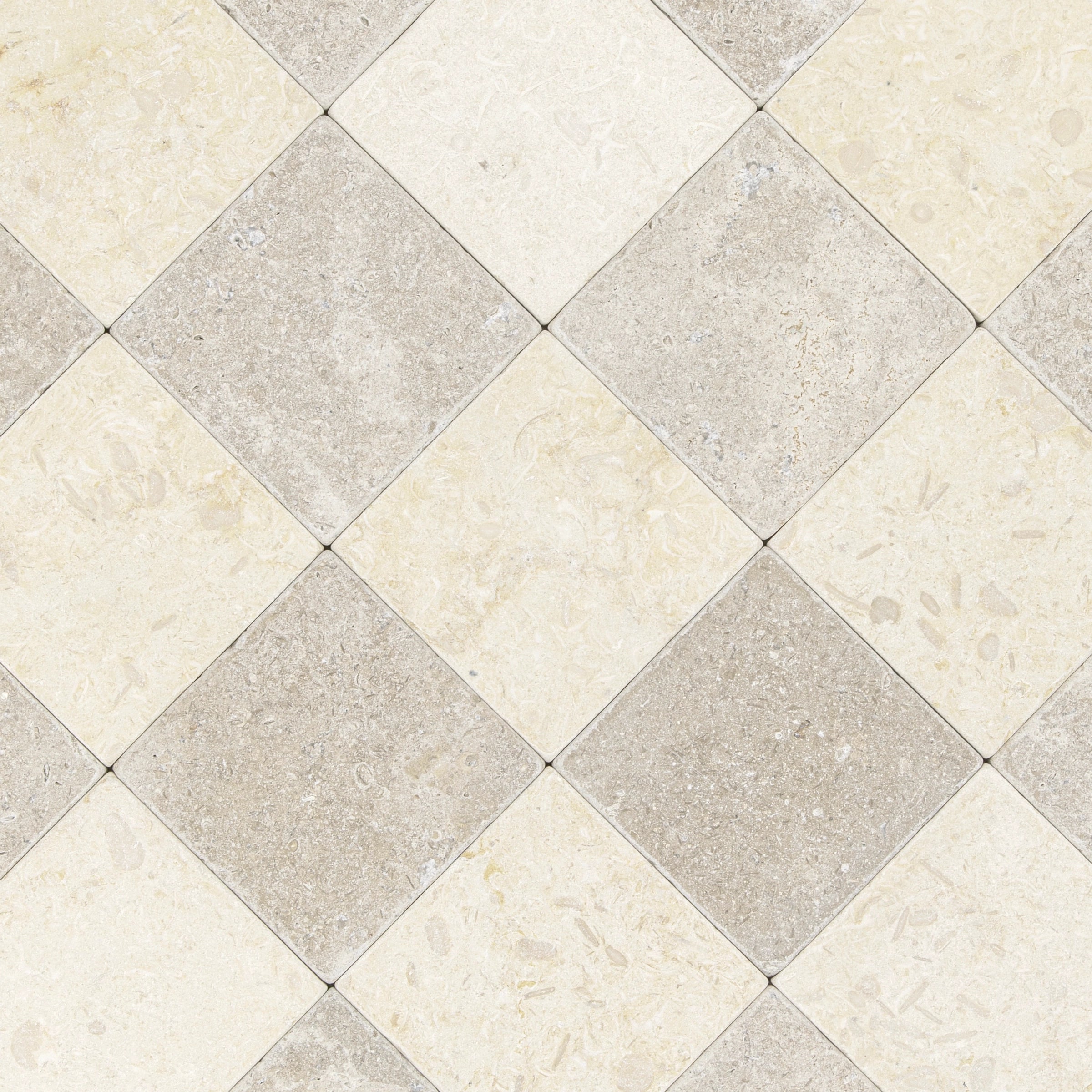 Alternating diamond pattern of tumbled stone tiles in soft cream and warm taupe with natural mineral textures
