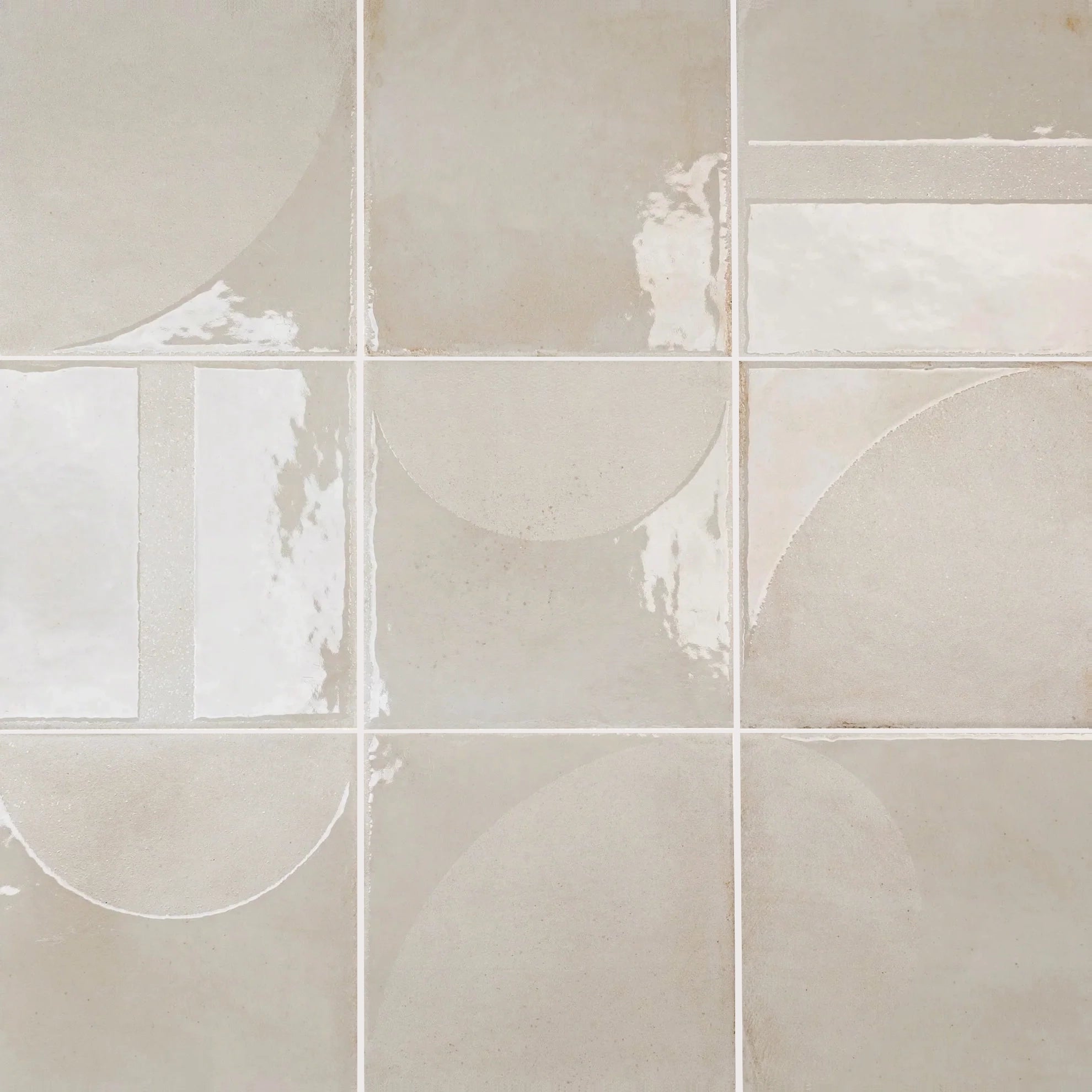 Glossy neutral-toned porcelain tiles featuring abstract, overlapping curved shapes with a smooth reflective finish