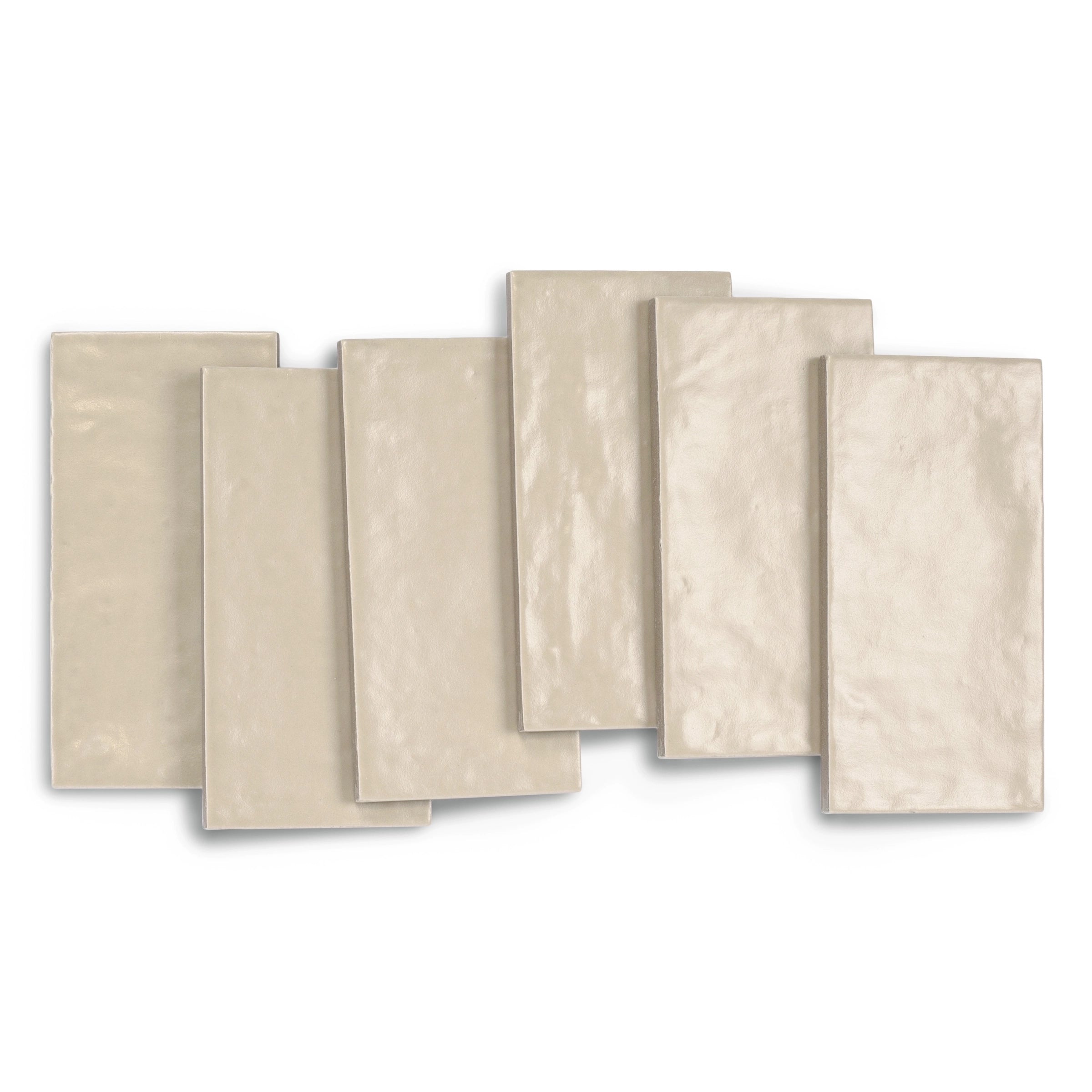 Glossy rectangular porcelain tiles in soft neutral beige tones arranged overlapping on a white background
