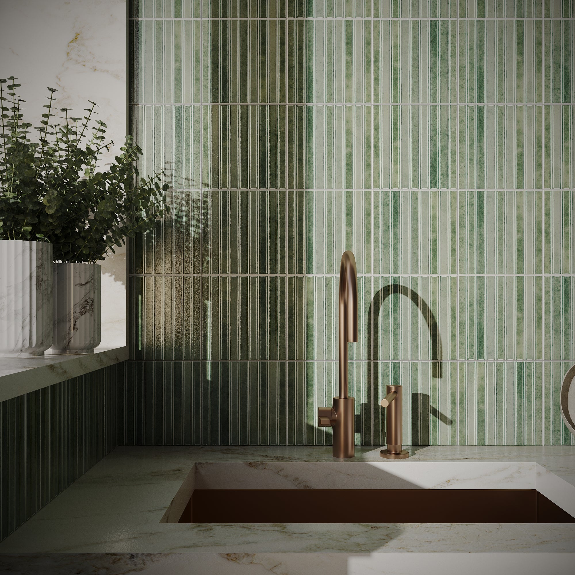 Glossy vertical ceramic tiles in varying shades of green create a textured backsplash behind a rose gold faucet with marble countertop.