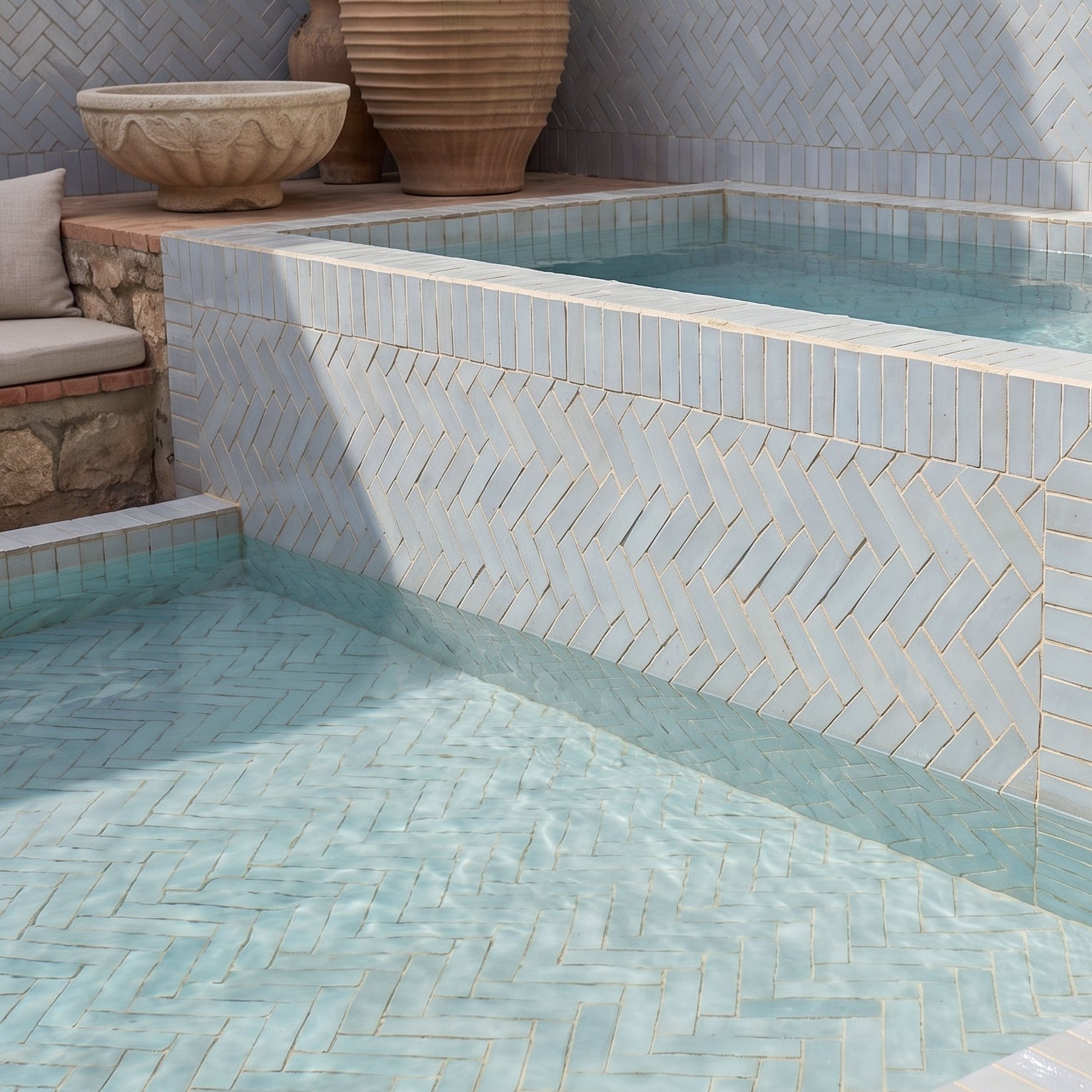 Glacier Glazed Zellige Plinth surrounding a decorative pool area with handmade Moroccan tiles in an outdoor setting