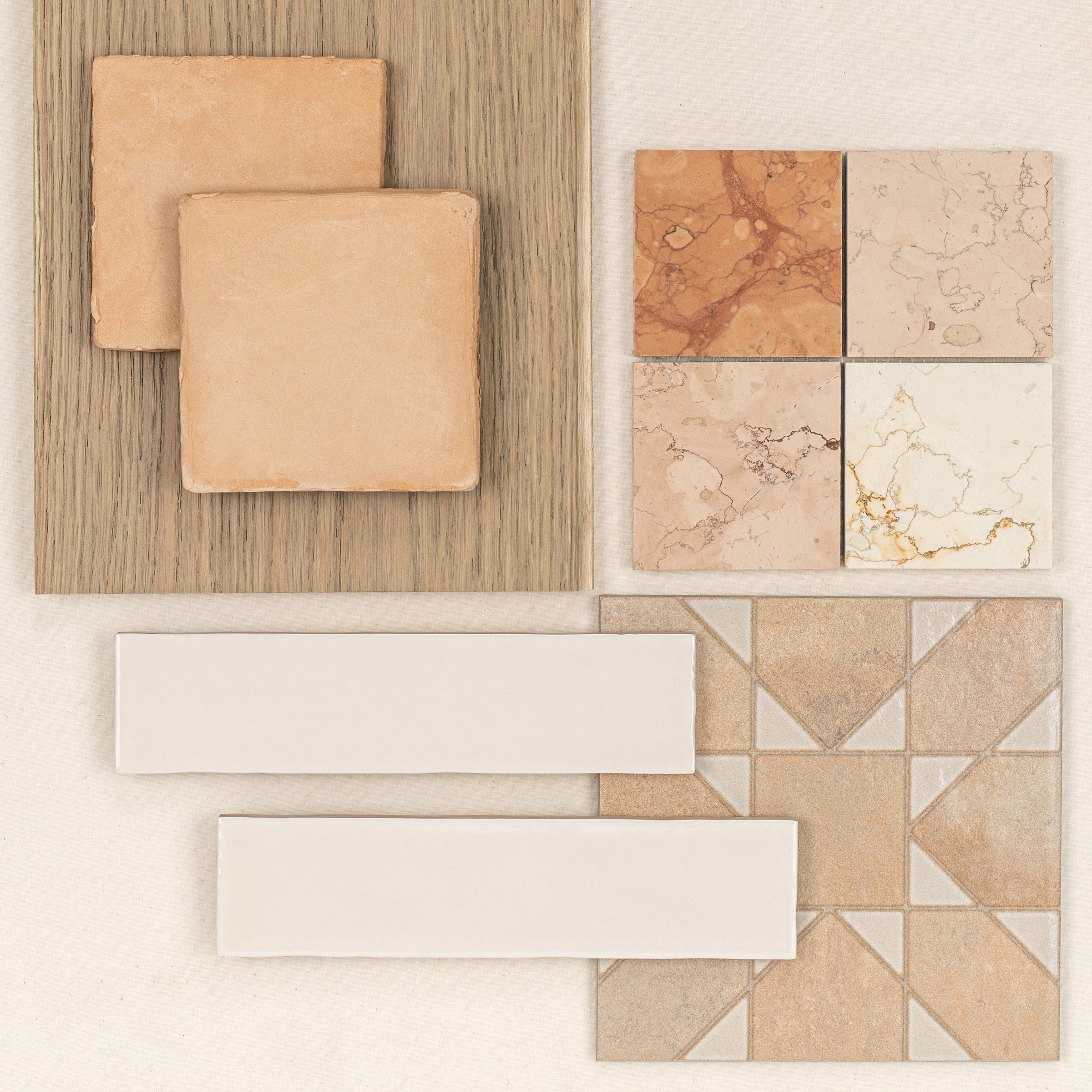 Arrangement of terracotta and marble-inspired ceramic tiles with wood texture and geometric mosaic on light background